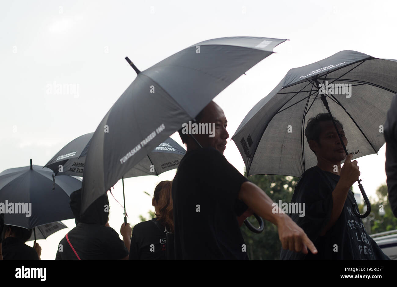 Jakarta, Jakarta, Indonesia. 16th May, 2019. Demonstrators seen with black umbrellas during the protest.The Victim Solidarity Network for Justice (JSKK) held a silent protest in front of the Presidential Palace in Jakarta. The act is commonly known as Aksi Kamisan and this was its 586th day and the demand is for the President to resolve human rights violations in the May 1998 Tragedy: Trisakti - Semanggi I - Semanggi II and May 13-15 1998 Riots. Credit: Nick Hanoatubun/SOPA Images/ZUMA Wire/Alamy Live News Stock Photo