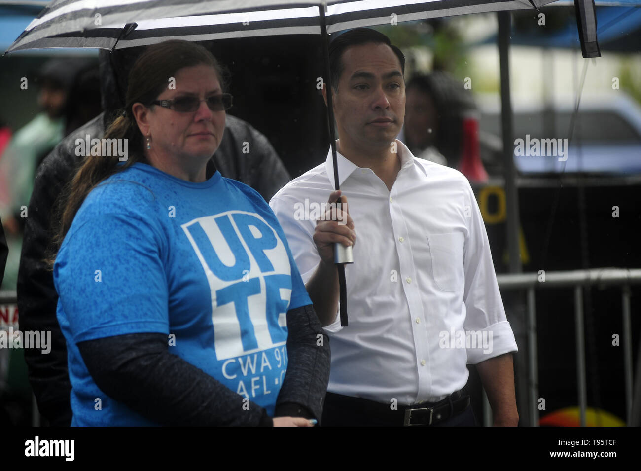 San Francisco, CA, USA. 16th May, 2019. San Francisco, CA, U.S. - University Professional and Technical Employees Union President JAMIE MCDOLE, left and presidential candidate JULIÃƒÂN CASTRO wait in the rain before they both spoke to the union members striking at the UCSF medical campus in San Francisco. Credit: Neal Waters/ZUMA Wire/Alamy Live News Stock Photo