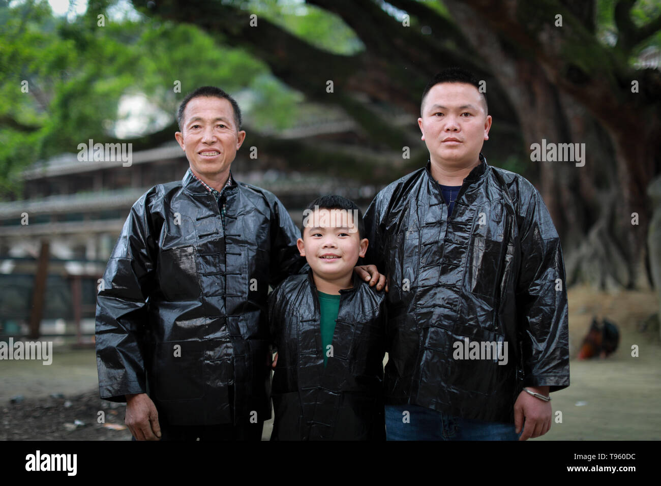 (190516) -- SIZHAI VILLAGE, May 16, 2019 (Xinhua) -- Wu You (C), an 8-year-old villager of Dong ethnic group at Sizhai Village, poses with his father Wu Fagui (R) and his grandfather Wu Zhiji in Sizhai Village of Shuangjiang Township, Liping County, Miao-Dong Autonomous Prefecture of Qiandongnan, southwest China's Guizhou Province, April 17, 2019. Wu You has been practising traditional wrestling of Dong ethnic group coached by his father Wu Fagui, a former champion of traditional wrestling competition. In April, he competed as the youngest player of Sizhai Village in the annual Wrestling Festi Stock Photo
