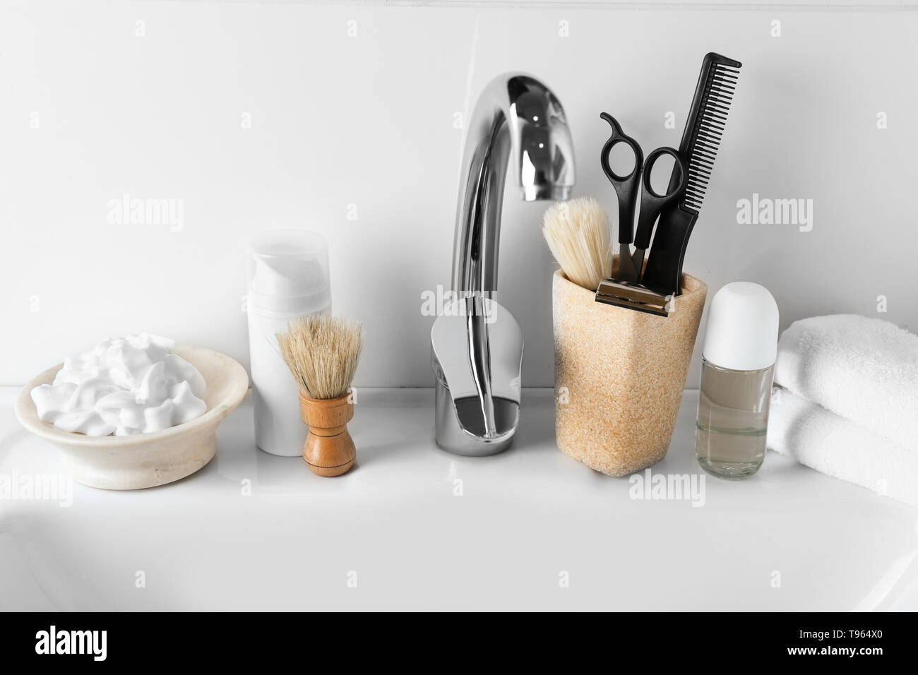 Shaving accessories with cosmetics for men on sink in bathroom Stock Photo