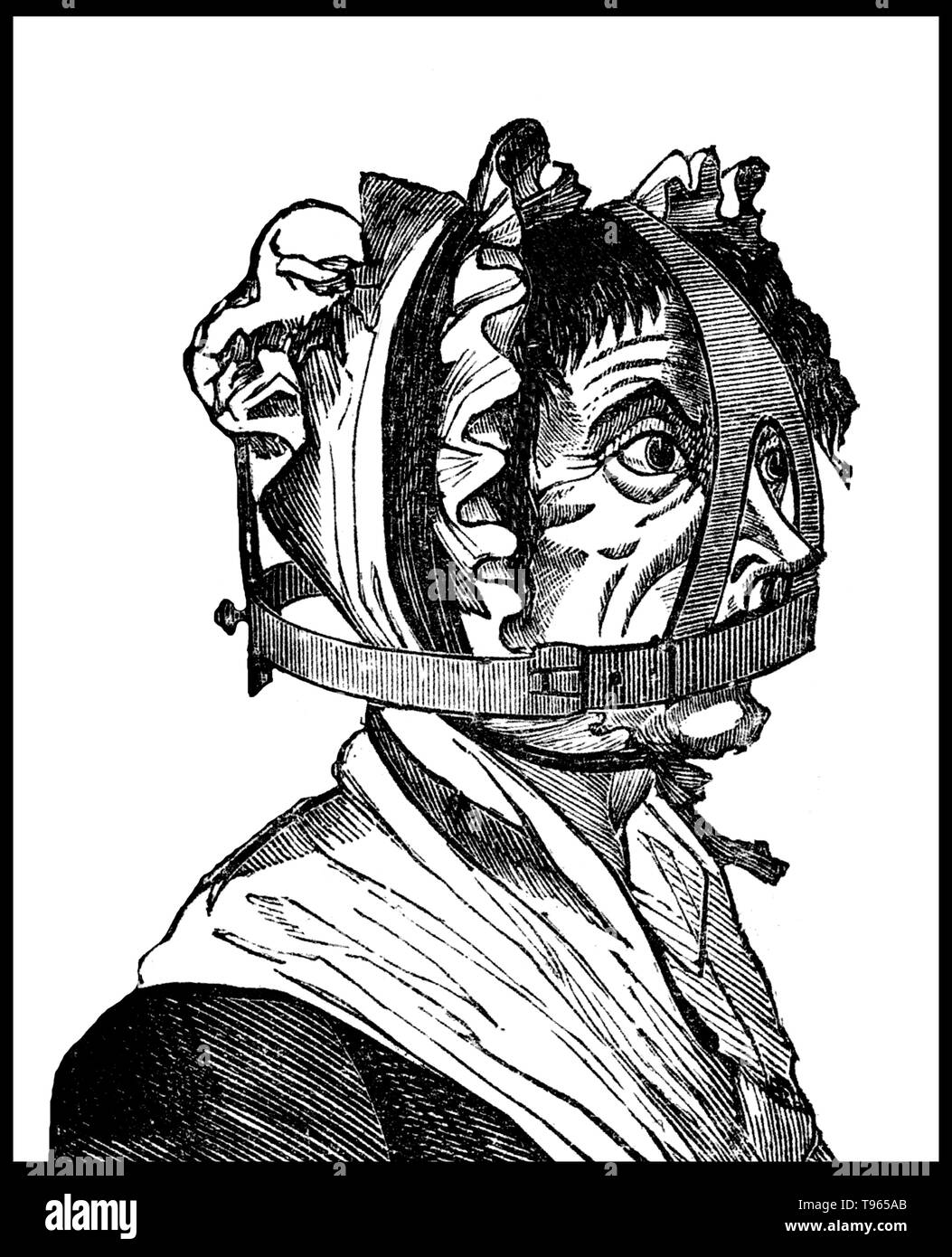 A scold's bridle was an instrument of punishment, as a form of torture and public humiliation. The device was an iron muzzle in an iron framework that enclosed the head. A bridle-bit, about 2 inches long and 1 inch broad, projected into the mouth and pressed down on top of the tongue. Stock Photo