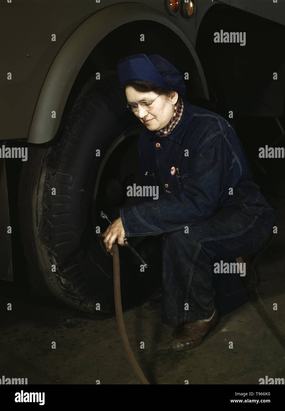 War production workers at the Heil Company making gasoline trailer tanks for the U.S. Army Air Corps, Milwaukee, Wisconsin. Mrs. Angeline Kwint, age 45, an ex-housewife, checking the tires of trailers. Her husband and son are in the U.S. Army. Although the image of 'Rosie the Riveter' reflected the industrial work of welders and riveters, the majority of working women filled non-factory positions in every sector of the economy. Photographed by Howard R. Hollem, 1943. Stock Photo