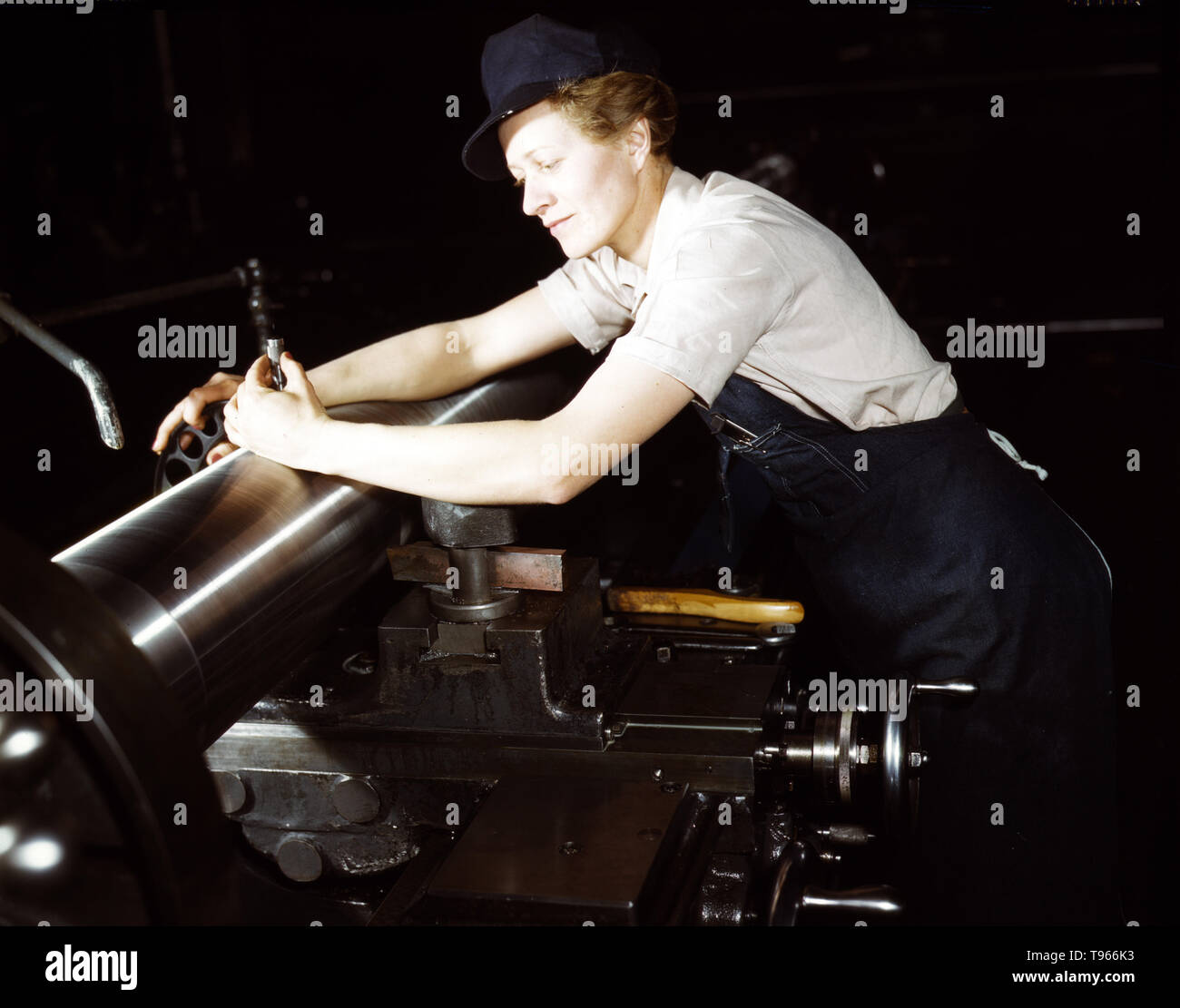 War production workers at the Vilter Manufacturing Company making M5 and M7 guns for the U.S. Army, Milwaukee, Wis. Ex-stage orchestra musician, checking an M7 gun with gage, after turning out on a gun lathe. Her two brothers and husband are in the service Although the image of 'Rosie the Riveter' reflected the industrial work of welders and riveters, the majority of working women filled non-factory positions in every sector of the economy.  Photographed by Howard R. Hollem, 1943. Stock Photo