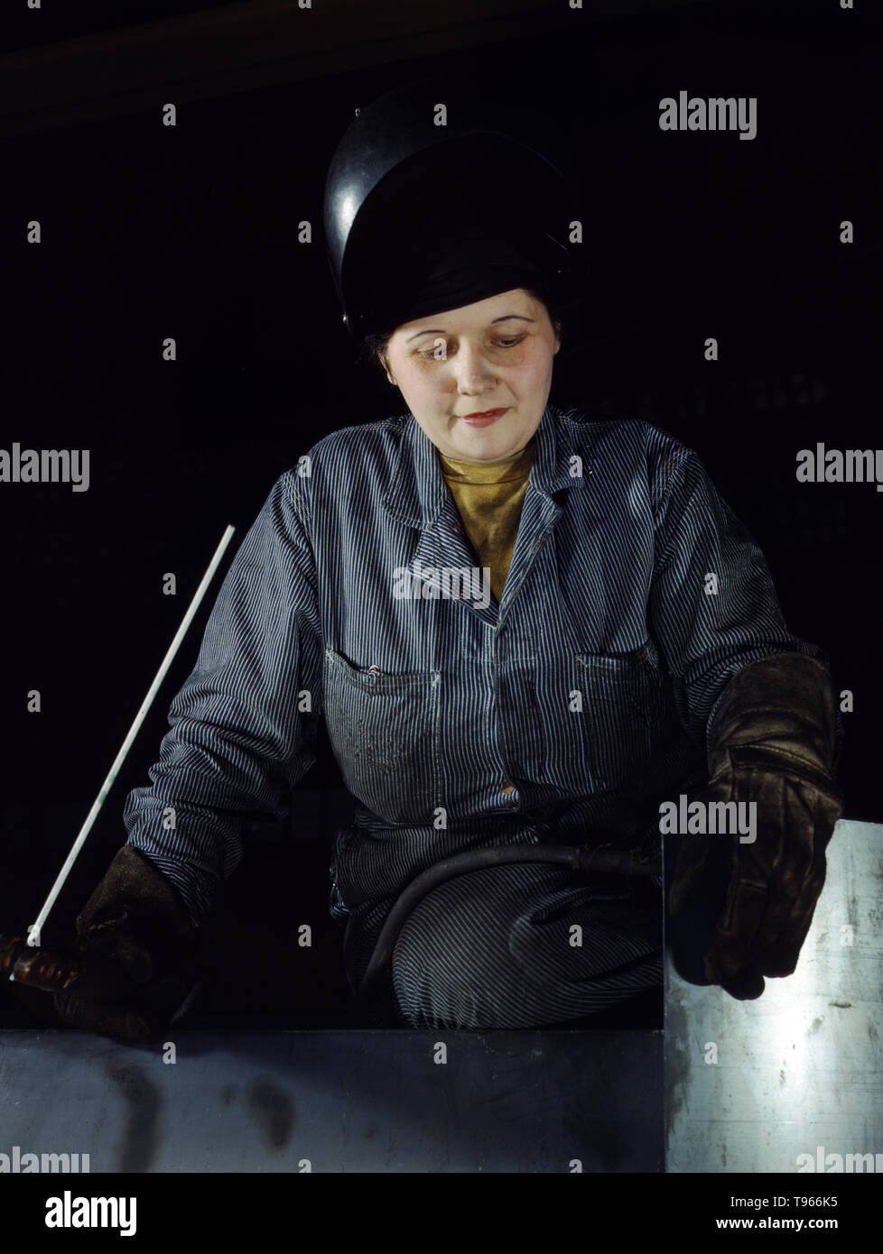 Enola O'Connell, age 32, widow and mother of one child. Ex-housewife, now she is the only woman welder at Heil and Company, Milwaukee, Wisconsin. Although the image of 'Rosie the Riveter' reflected the industrial work of welders and riveters, the majority of working women filled non-factory positions in every sector of the economy. What unified the experiences of these women was that they proved to themselves, and the country, that they could do a man's job and could do it well. Photographed by Howard R. Hollem, 1943. Stock Photo