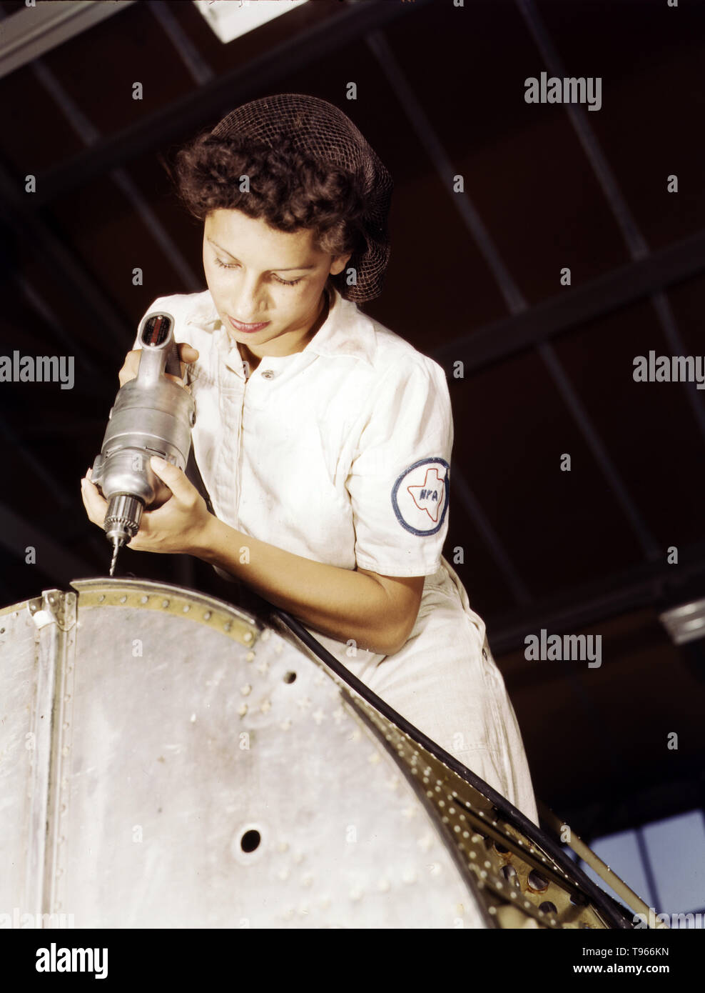 A rivet is her fighting weapon. Oyida Peaks, daughter of a Navy lieutenant, one of many women taking NYA training to become mechanics at the Naval Air Base, Corpus Christi, Texas. After eight weeks apprenticeship she will be qualified as a civil service worker in the Assembly and Repair Department. Photographed by Howard R. Hollem, 1942. Stock Photo