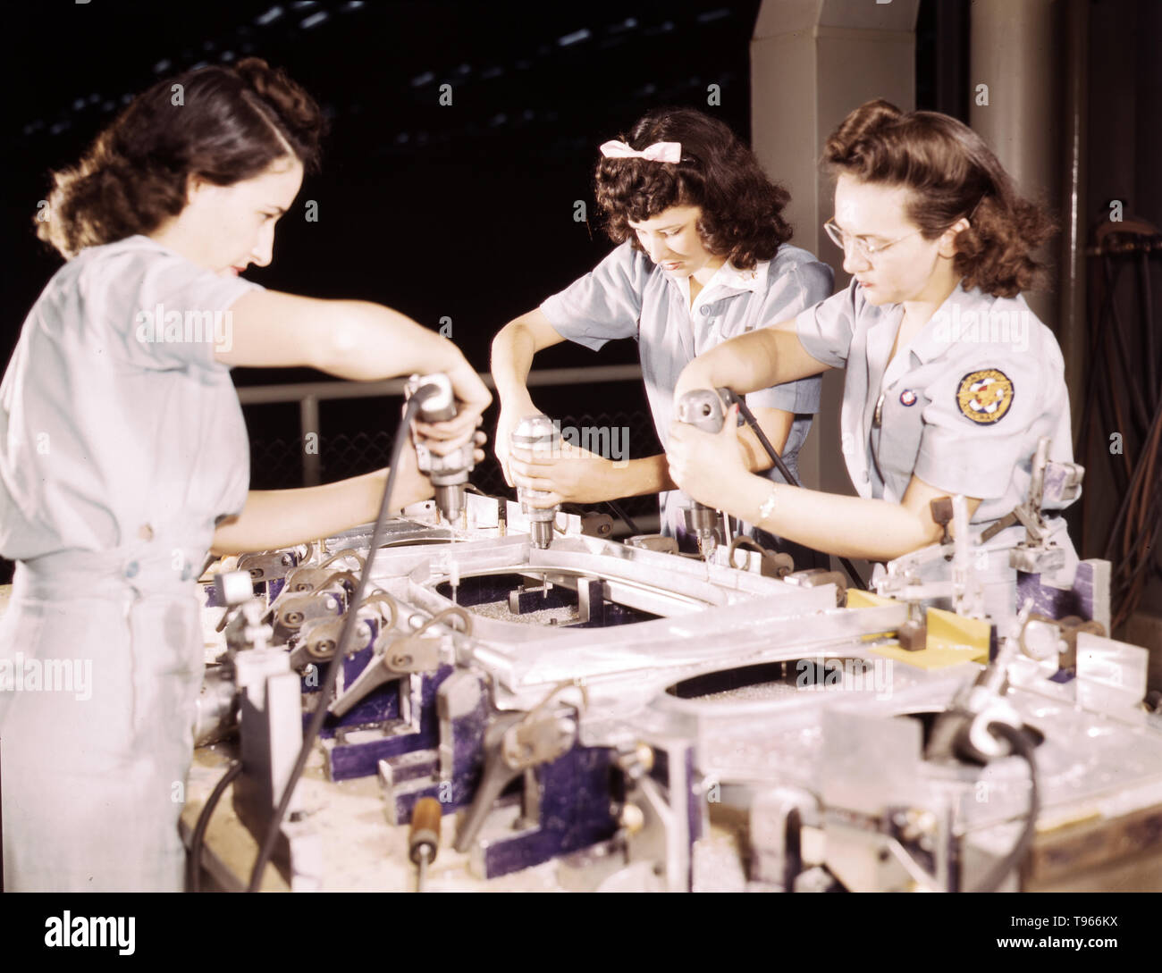 Drilling a wing bulkhead for a transport plane at the Consolidated Aircraft Corporation plant, Fort Worth, Texas. Although the image of 'Rosie the Riveter' reflected the industrial work of welders and riveters, the majority of working women filled non-factory positions in every sector of the economy. What unified the experiences of these women was that they proved to themselves, and the country, that they could do a man's job and could do it well. Photographed by Howard R. Hollem, 1942. Stock Photo