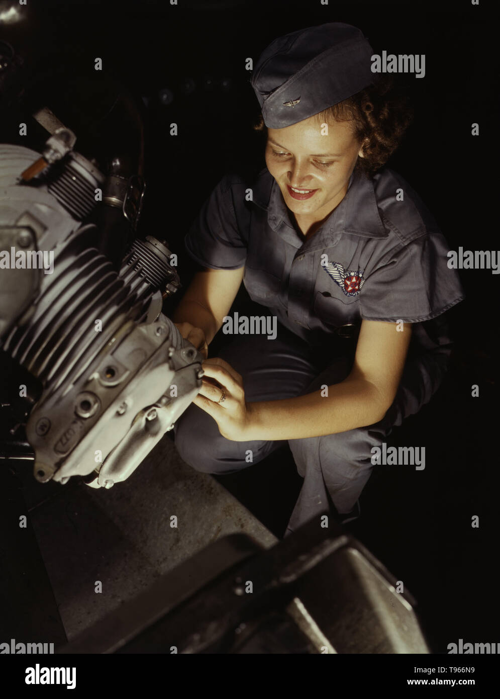 Assembly and Repairs Department mechanic Mary Josephine Farley works on a Wright Whirlwind motor, Naval Air Base, Corpus Christi, Texas. Although the image of 'Rosie the Riveter' reflected the industrial work of welders and riveters, the majority of working women filled non-factory positions in every sector of the economy. What unified the experiences of these women was that they proved to themselves, and the country, that they could do a man's job and could do it well. Photographed by Howard R. Hollem, 1942. Stock Photo