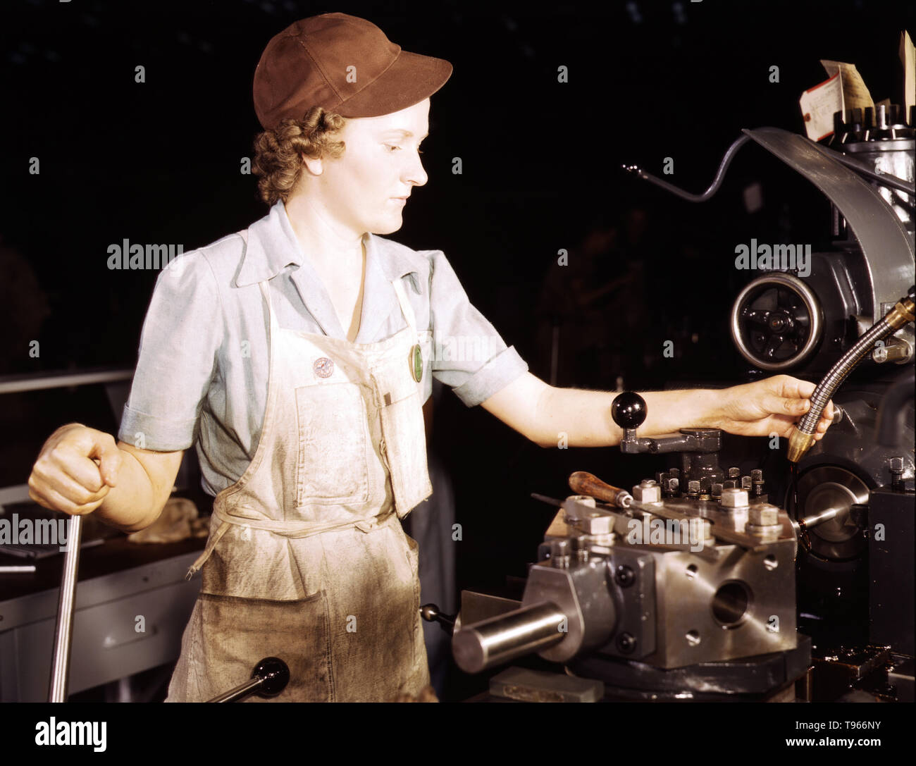 Beulah Faith, 20, used to be sales clerk in department store, reaming tools for transport on lathe machine, Consolidated Aircraft Corp., Fort Worth, Texas. Although the image of 'Rosie the Riveter' reflected the industrial work of welders and riveters, the majority of working women filled non-factory positions in every sector of the economy. What unified the experiences of these women was that they proved to themselves, and the country, that they could do a man's job and could do it well. Photographed by Howard R. Hollem, 1942. Stock Photo