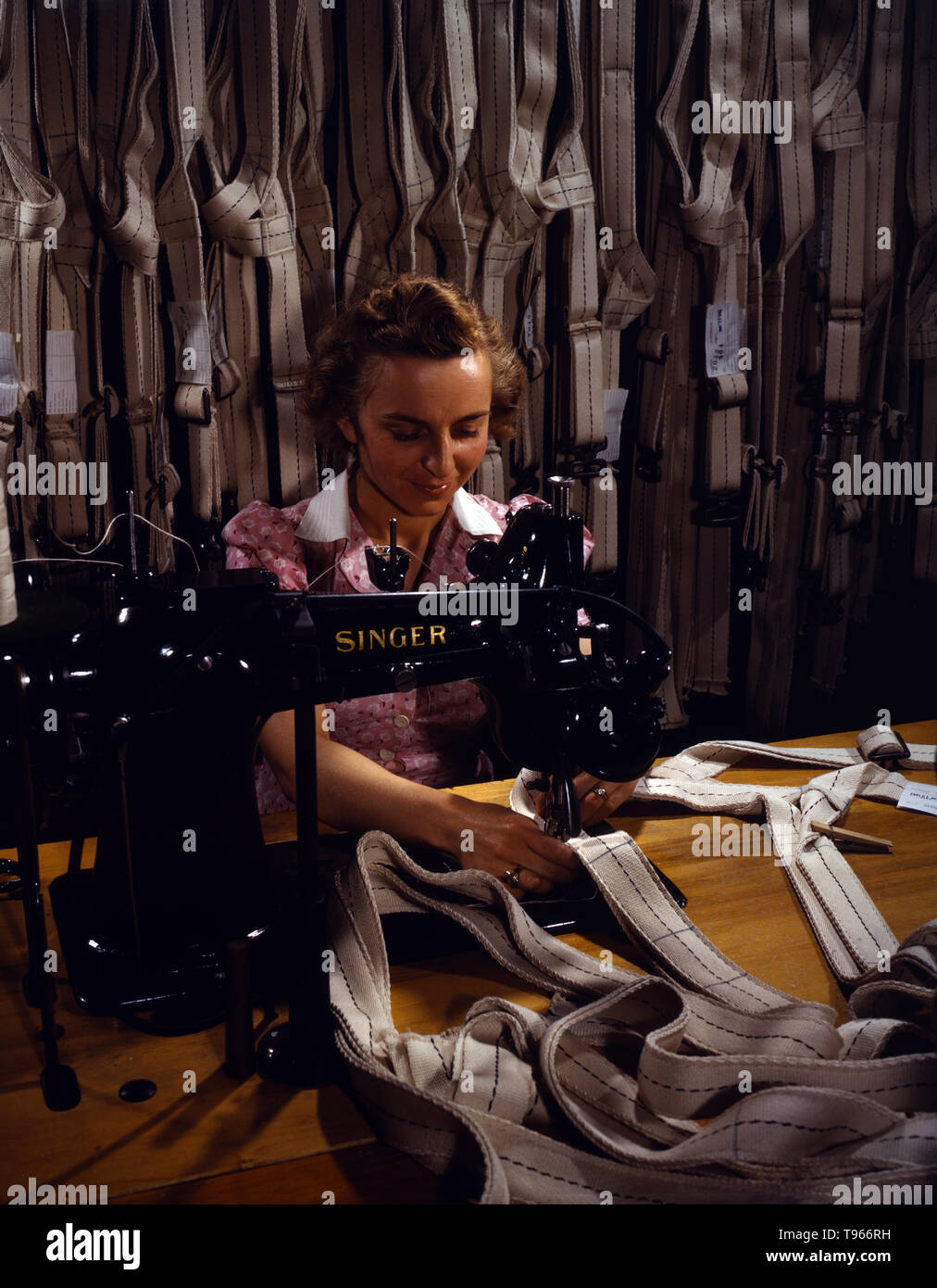 Making harnesses, Mary Saverick stitching, Pioneer Parachute Company Mills, Manchester, Connecticut. Although the image of 'Rosie the Riveter' reflected the industrial work of welders and riveters, the majority of working women filled non-factory positions in every sector of the economy. What unified the experiences of these women was that they proved to themselves, and the country, that they could do a man's job and could do it well. Photographed by William M. Rittase, 1942. Stock Photo