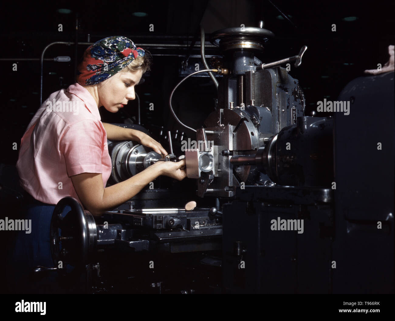 Woman machinist, Douglas Aircraft Company, Long Beach, California. Although the image of 'Rosie the Riveter' reflected the industrial work of welders and riveters, the majority of working women filled non-factory positions in every sector of the economy. What unified the experiences of these women was that they proved to themselves, and the country, that they could do a man's job  and could do it well. Photographed by Alfred T. Palmer, 1942. Stock Photo