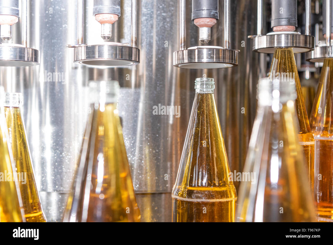 Filling glass bottles with juice. Bottling of drinks. bottling plant