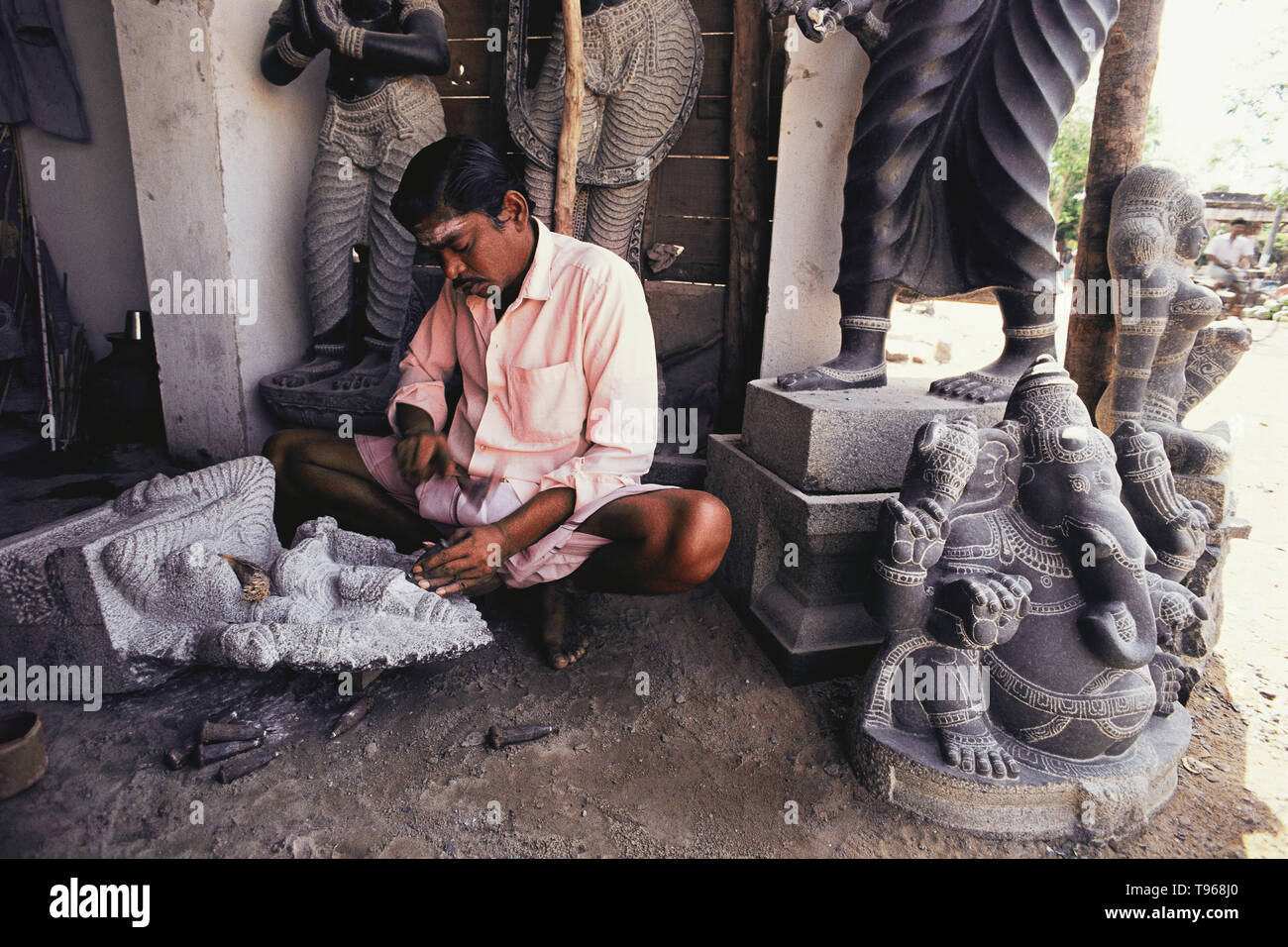 STONE CARVER, CARVING AN IDOL OUT OF BLACK STONE,TRADITIONAL INDIAN