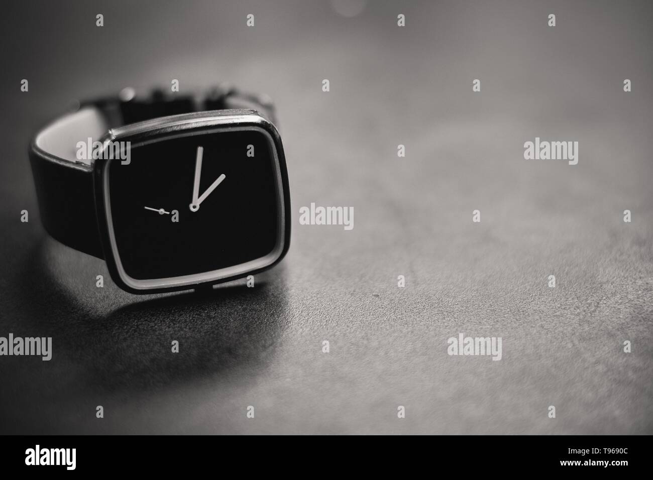 A dark analog clock on a stone surface Stock Photo
