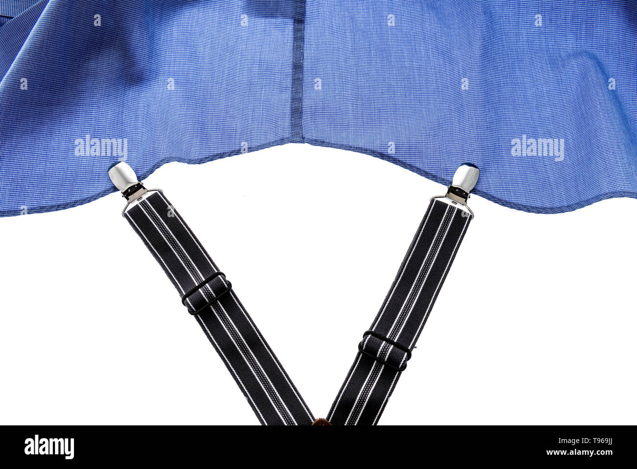 A shirt stay with metal clips clipped to a shirt on an isolated