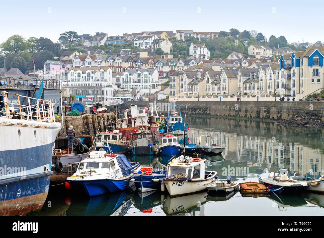 Fishing boats in a crowded Brixham Harbour and waterside houses Devon