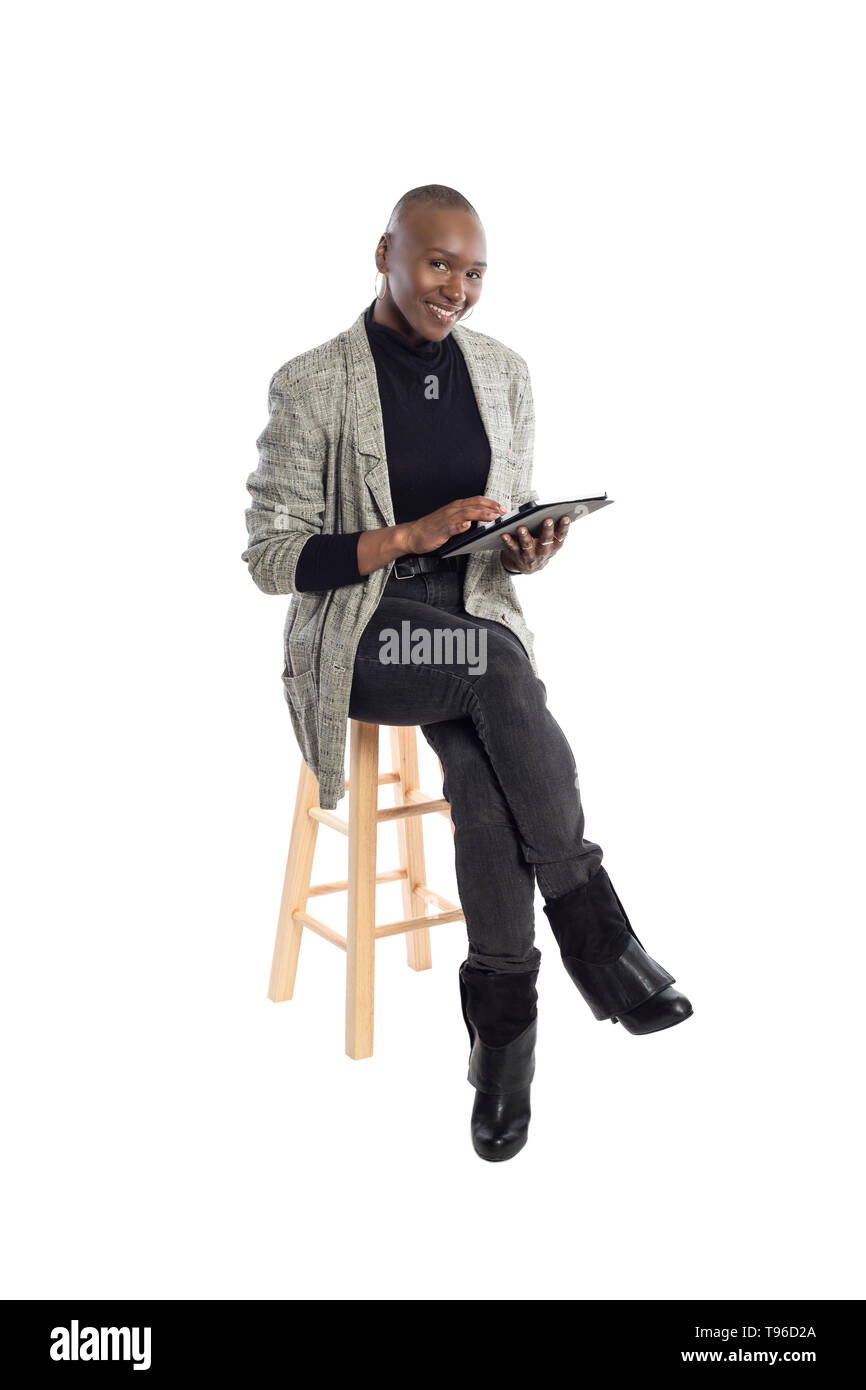 Black African American female teacher preparing her course or lessons online with a tablet computer.  She can aslo be a businesswoman preparing her ou Stock Photo