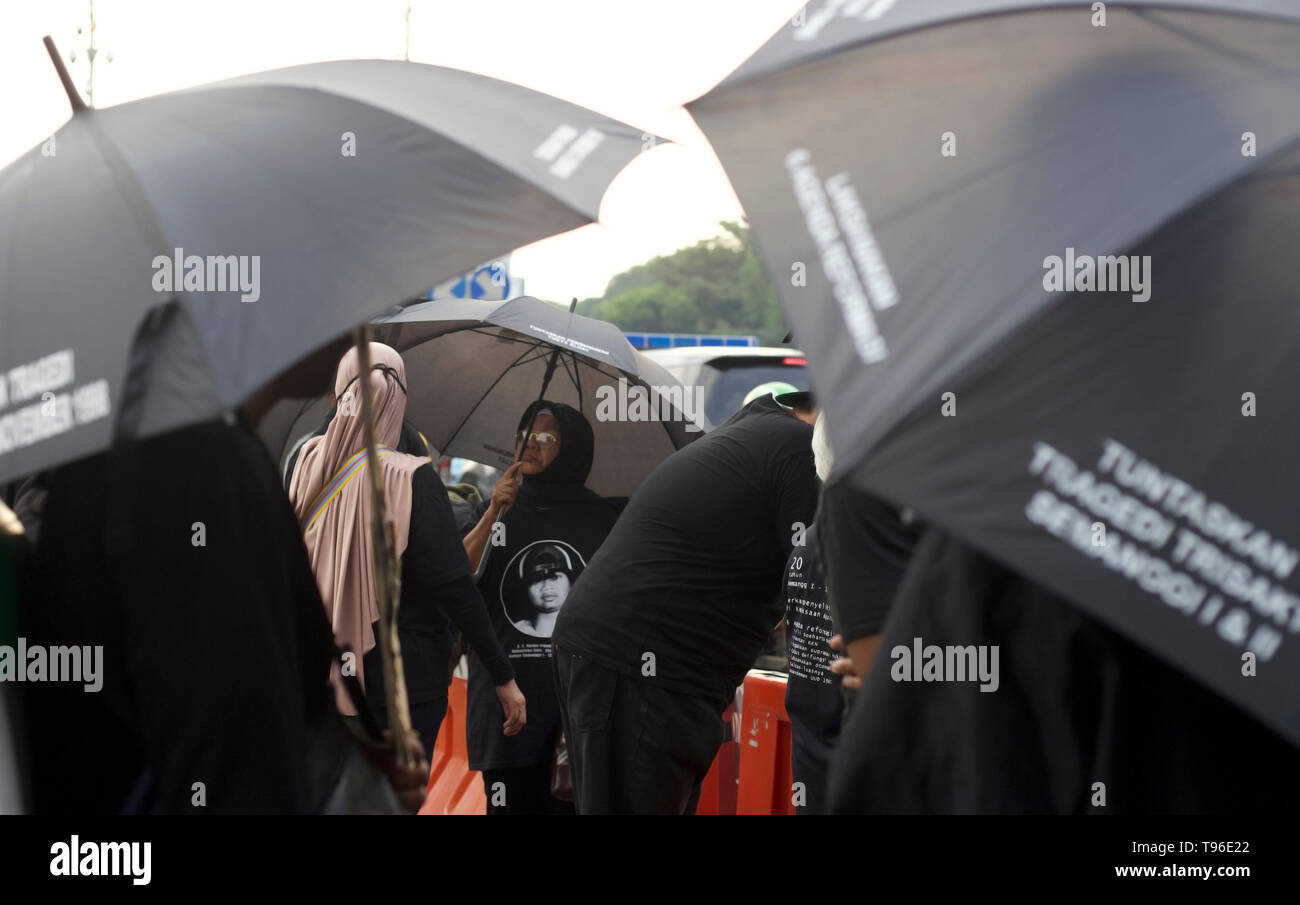 Demonstrators seen with black umbrellas during the protest. The Victim Solidarity Network for Justice (JSKK) held a silent protest in front of the Presidential Palace in Jakarta. The act is commonly known as Aksi Kamisan and this was its 586th day and the demand is for the President to resolve human rights violations in the May 1998 Tragedy: Trisakti - Semanggi I - Semanggi II and May 13-15 1998 Riots. Stock Photo
