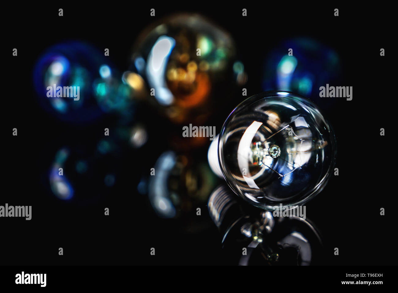 Retro light bulb with reflection on black table Stock Photo