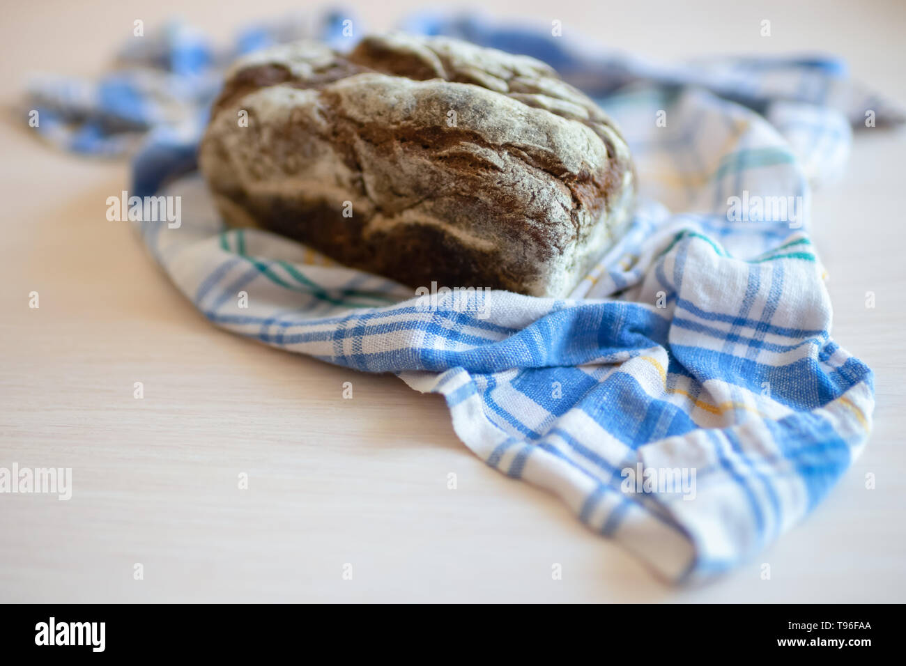 Brown bread on a table with a plaid towel Stock Photo