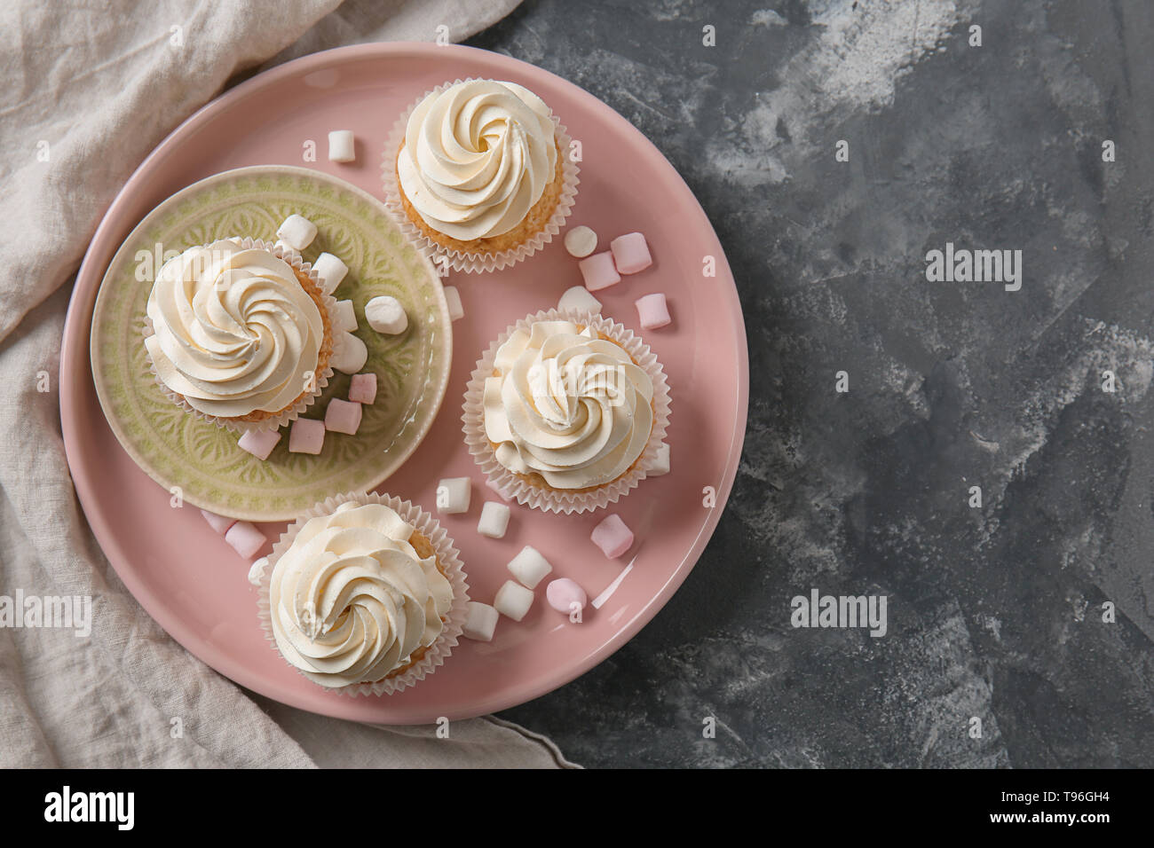Plate with delicious cupcakes and marshmallows on grey table Stock Photo