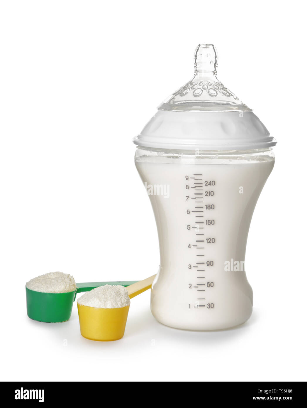 Bottle of milk for baby and measuring scoops with powder on white