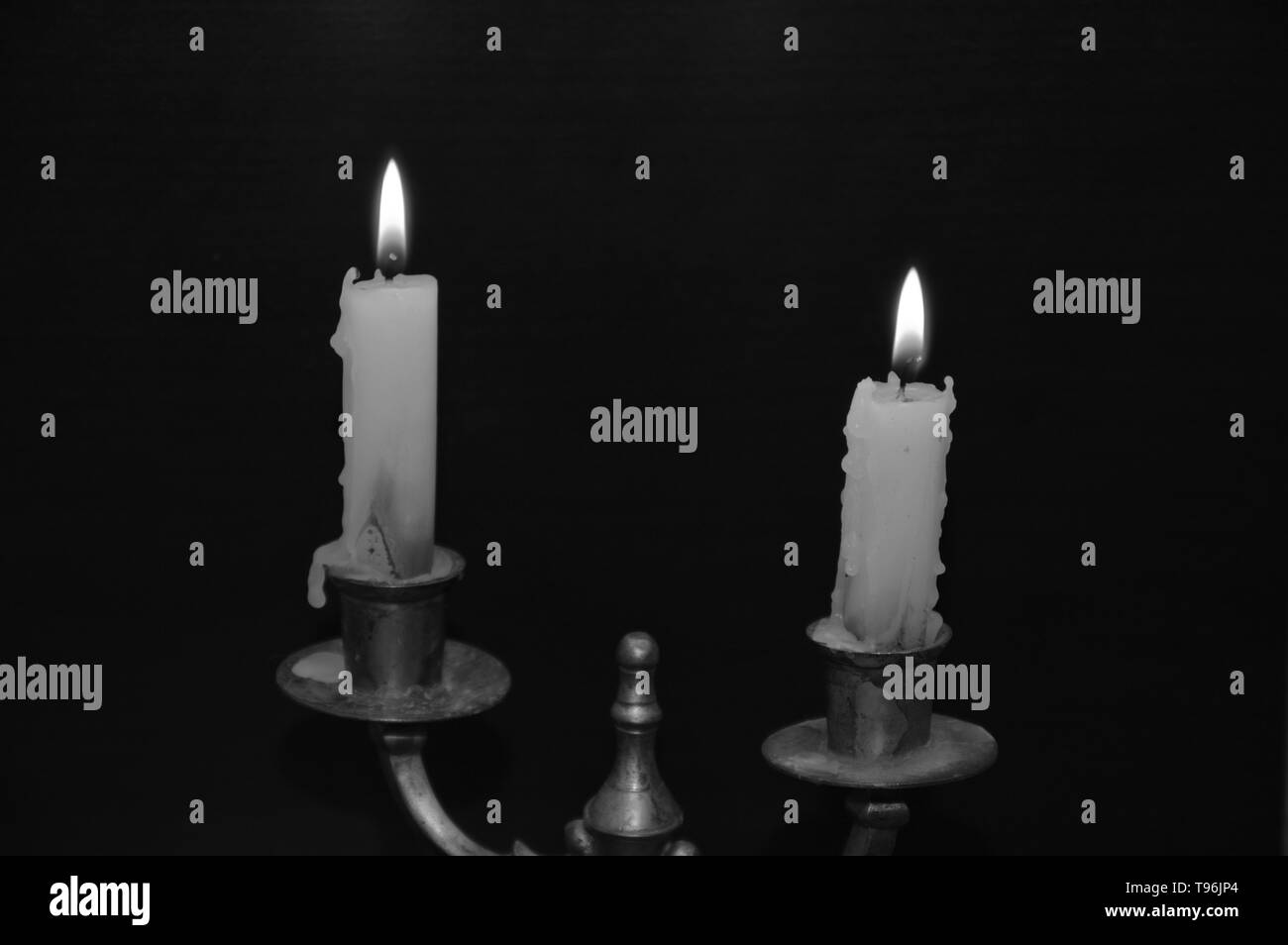 White candles on a black table ( on fire Stock Photo Alamy