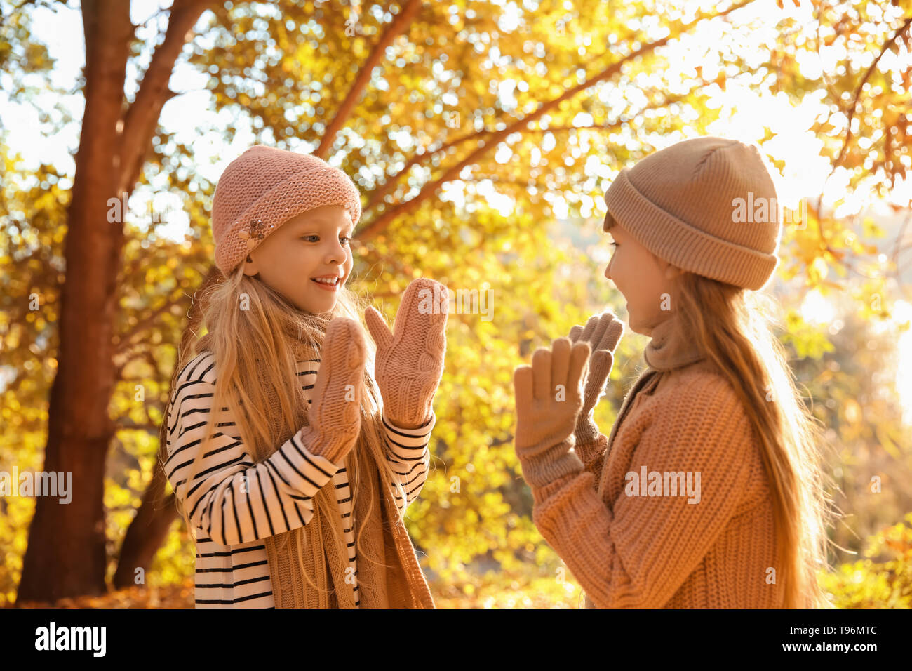 Cute little girls playing in autumn park Stock Photo - Alamy