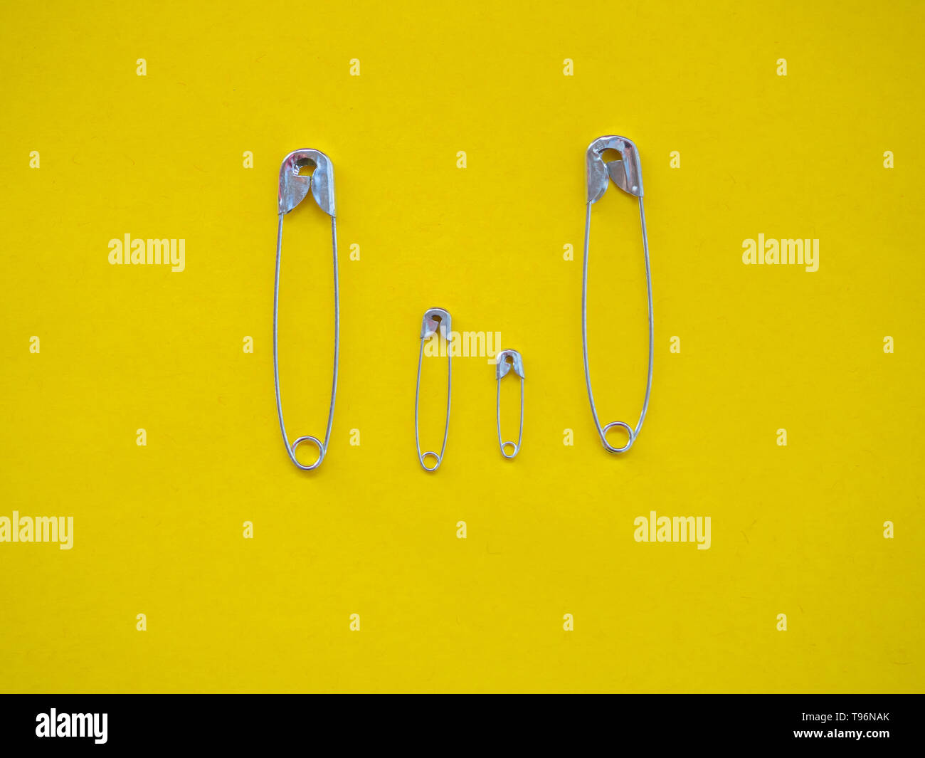 Several safety pins of various sizes in human representation. Concept of traditional family with children Stock Photo