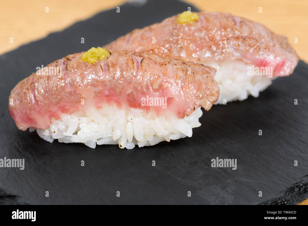 nigiri of heatburned kobe beef dressed with mustard, served on a