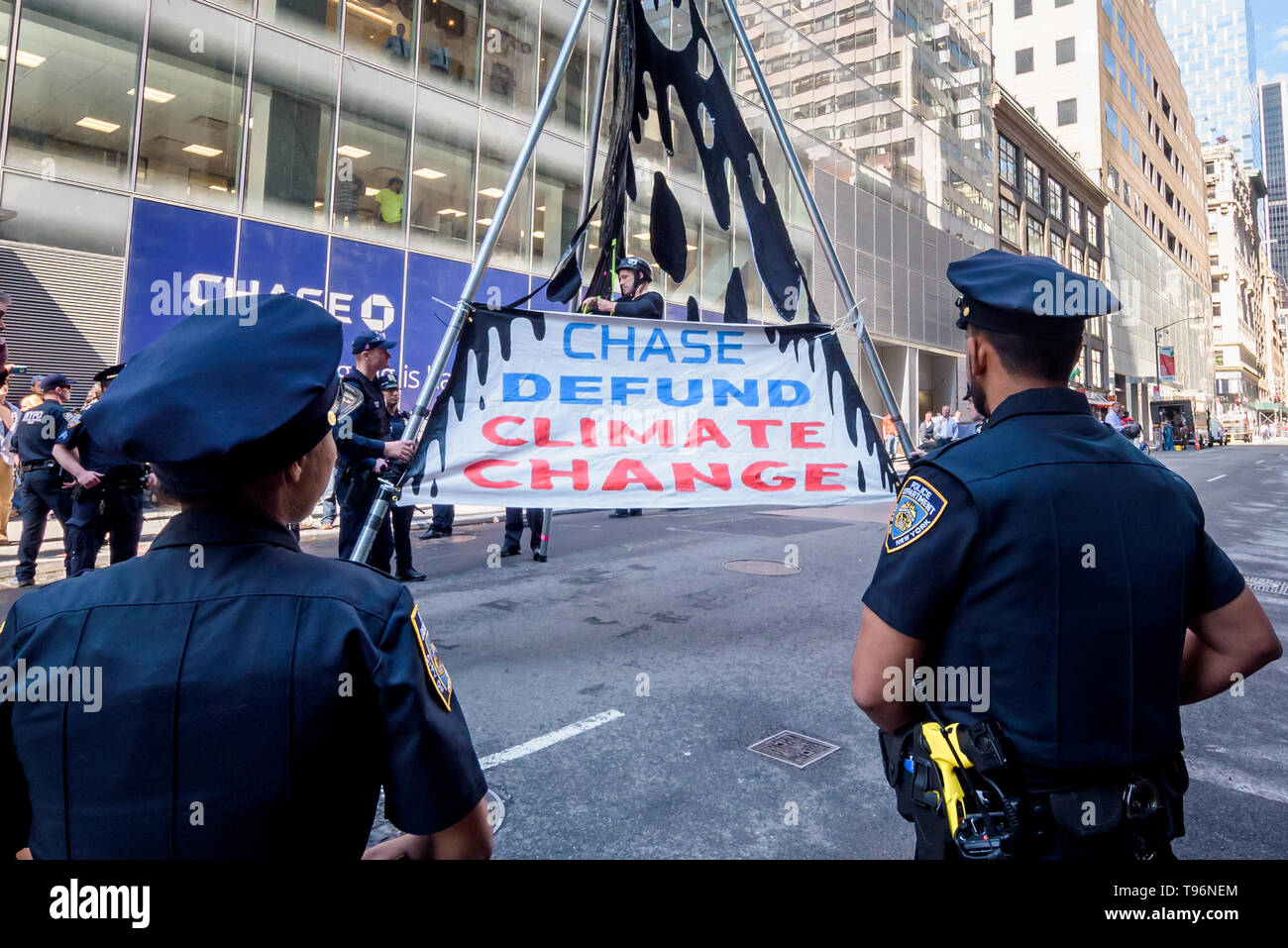 New York, United States. 16th May, 2019. Protests against Chase Bank for its role as the world's worst funder of climate change escalated as climate activists erected and scaled a two-story, steel tripod structure, blocking 47th St at Madison Ave, in front of Chase's new flagship global corporate headquarters. One arrest was while a group of supporting demonstrators chanted and displayed banners calling on Chase to end its massive funding of fossil fuels. Credit: Erik McGregor/Pacific Press/Alamy Live News Stock Photo