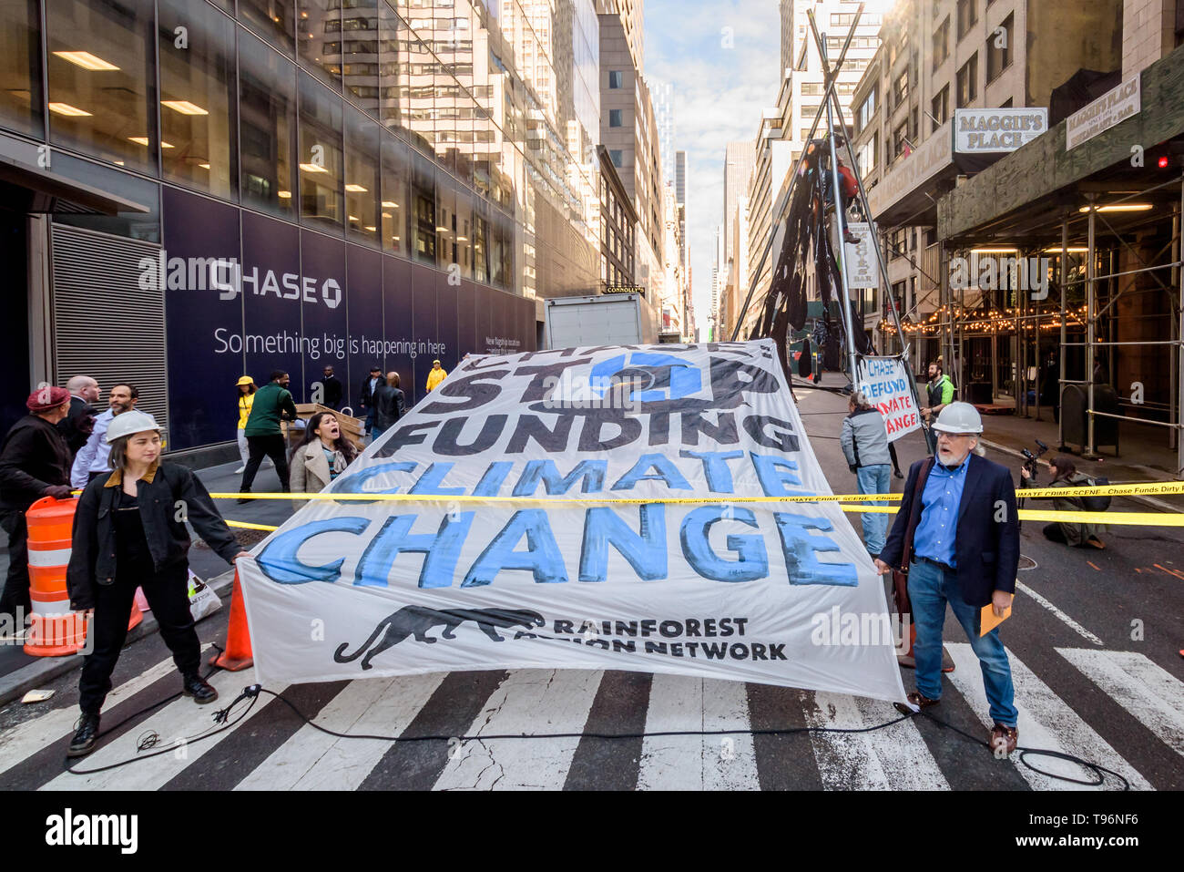 New York, United States. 16th May, 2019. Protests against Chase Bank for its role as the world's worst funder of climate change escalated as climate activists erected and scaled a two-story, steel tripod structure, blocking 47th St at Madison Ave, in front of Chase's new flagship global corporate headquarters. One arrest was while a group of supporting demonstrators chanted and displayed banners calling on Chase to end its massive funding of fossil fuels. Credit: Erik McGregor/Pacific Press/Alamy Live News Stock Photo