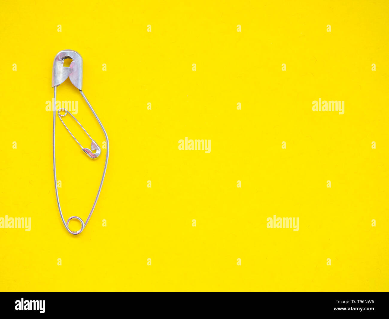 A safety pin representing a pregnant woman with a baby Stock Photo Alamy