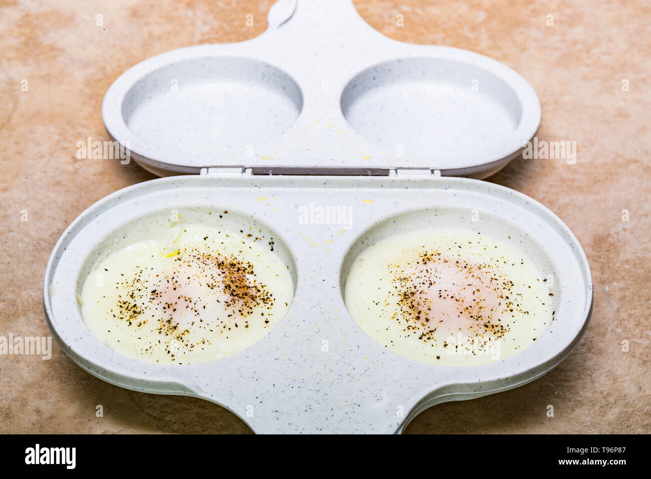 microwave two egg cooker with two cooked eggs Stock Photo - Alamy