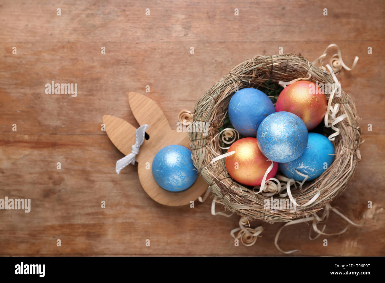 Nest with Easter eggs on wooden background Stock Photo