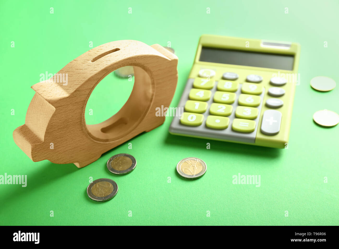 Piggy bank, coins and calculator on color table Stock Photo - Alamy