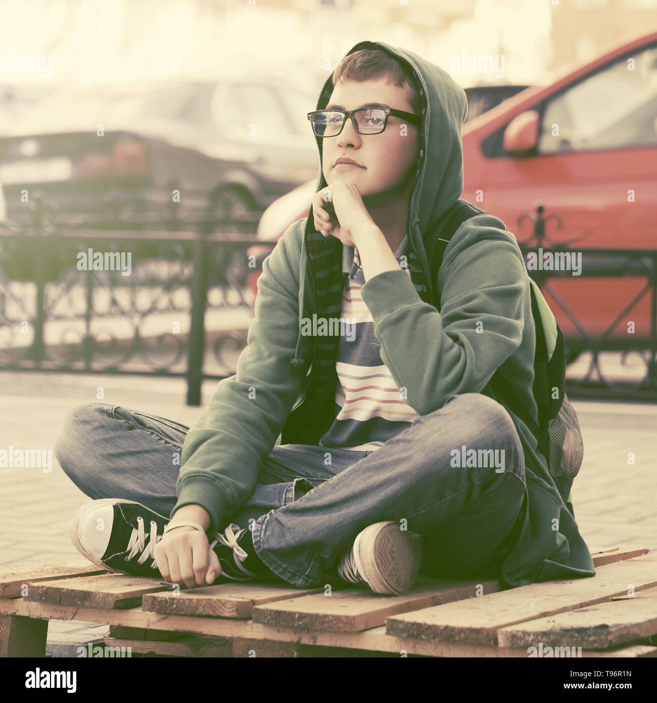 Sad teen boy in depression sitting on sidewalk in city street Stock ...