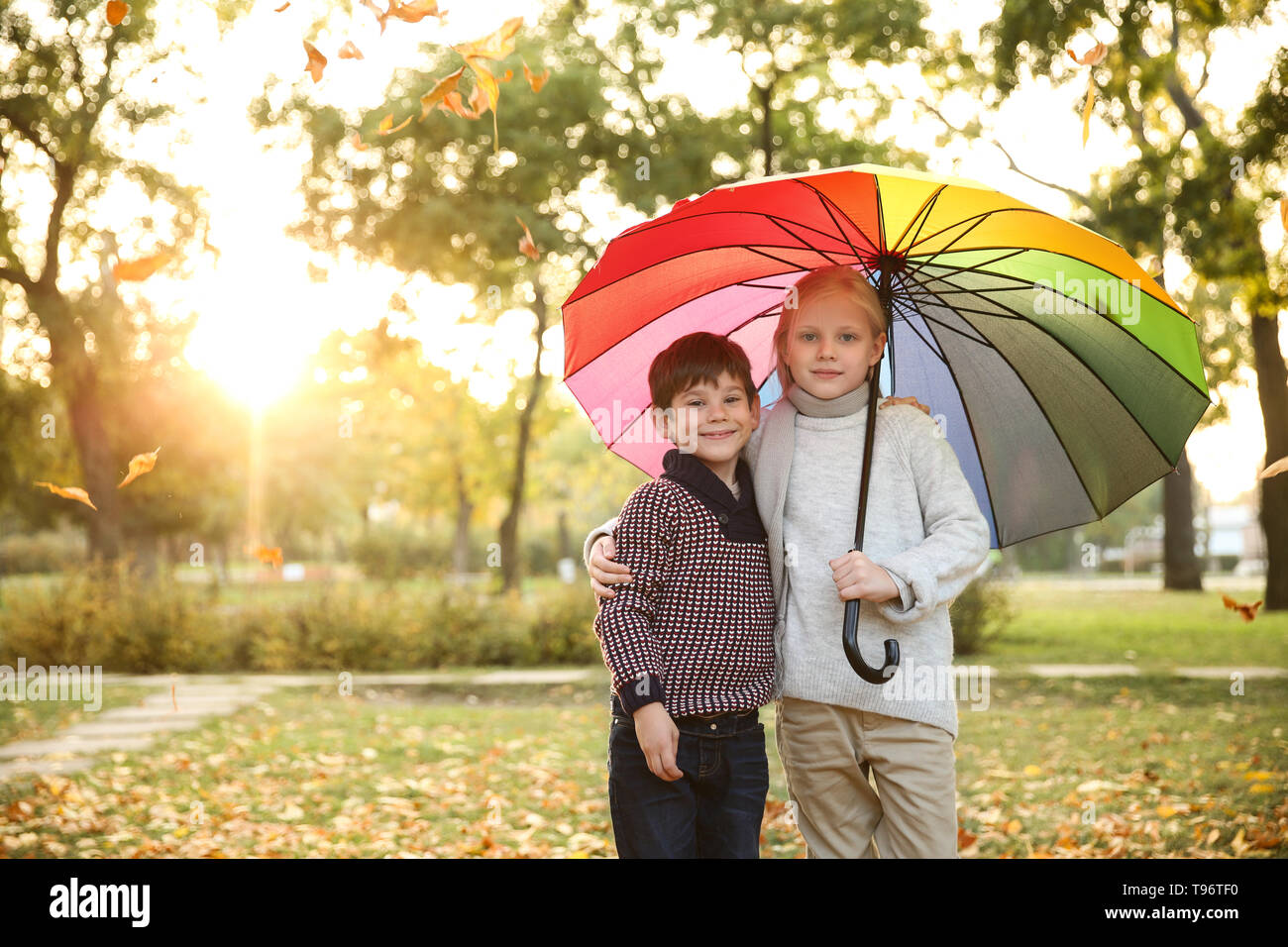 Cute little children with colorful umbrella in autumn park Stock Photo