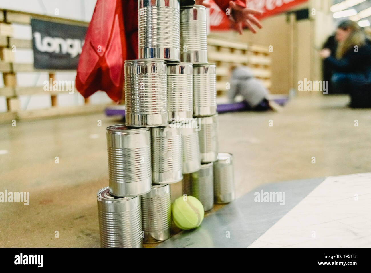 Valencia, Spain - March 31, 2019: Children playing to knock down a wall made with tin cans with balls. Stock Photo