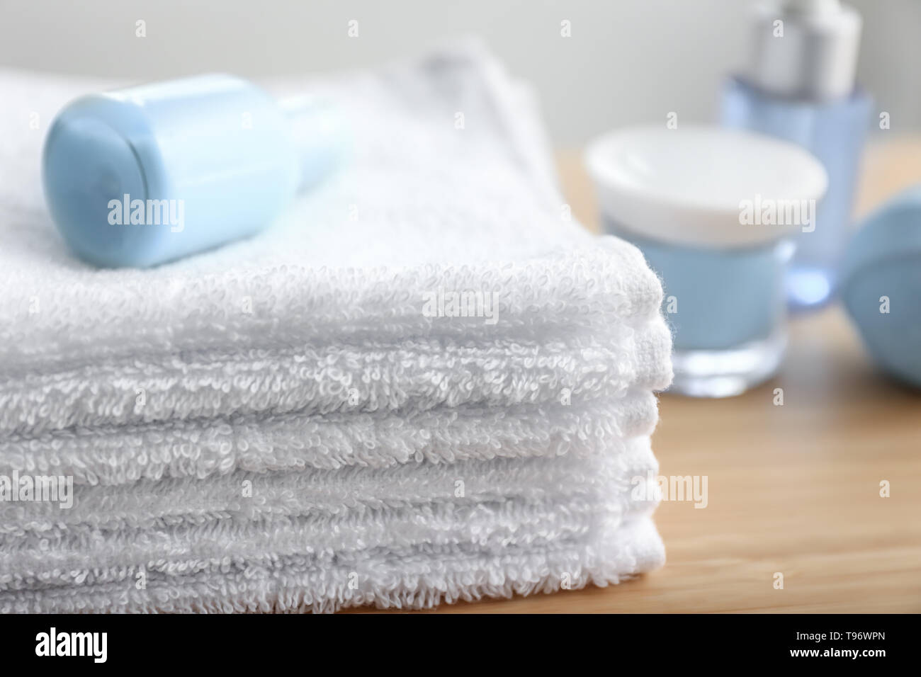 Folded white terry towels on table indoors Stock Photo