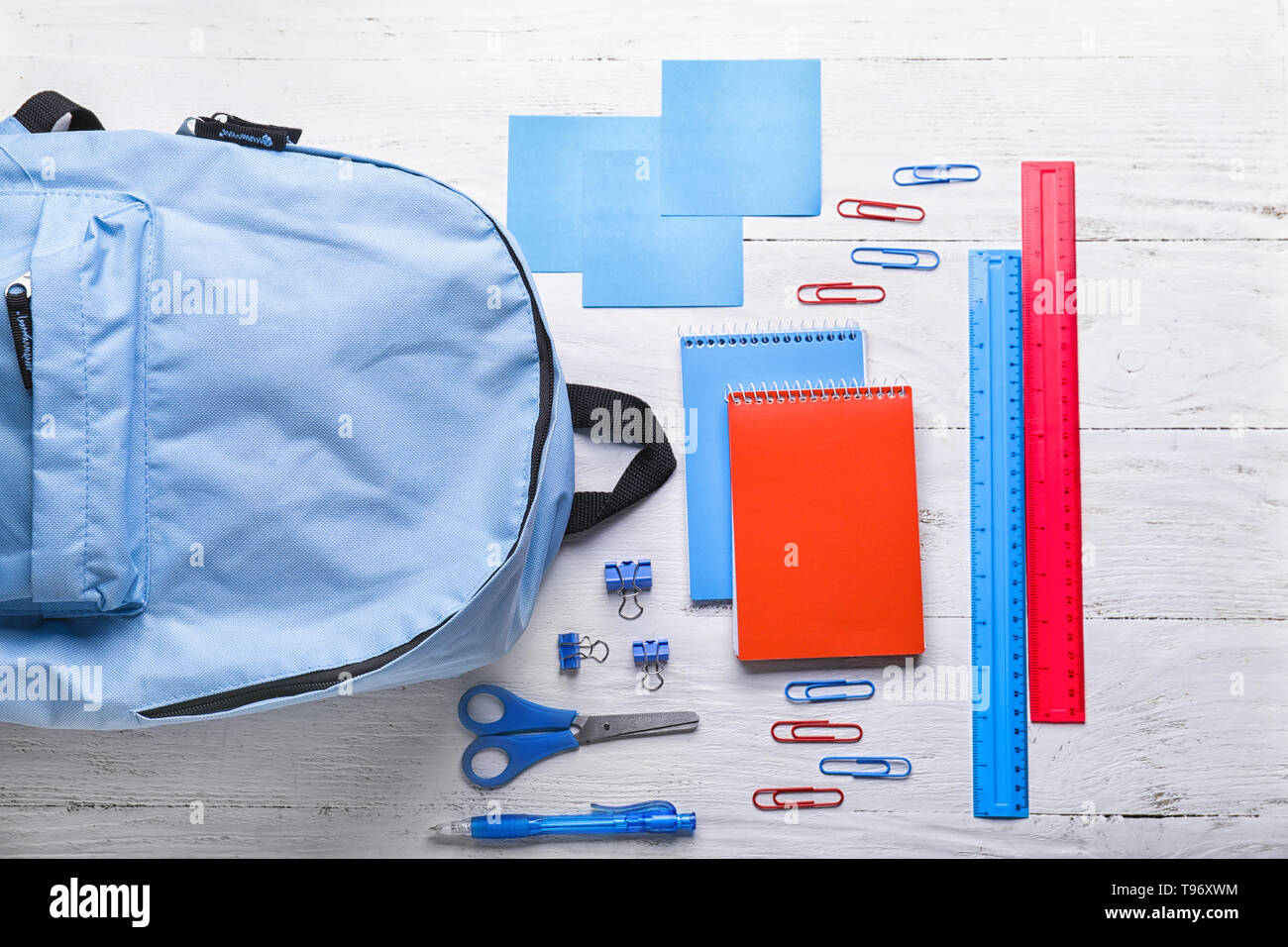 Composition with rucksack and school stationery on light background, top view Stock Photo