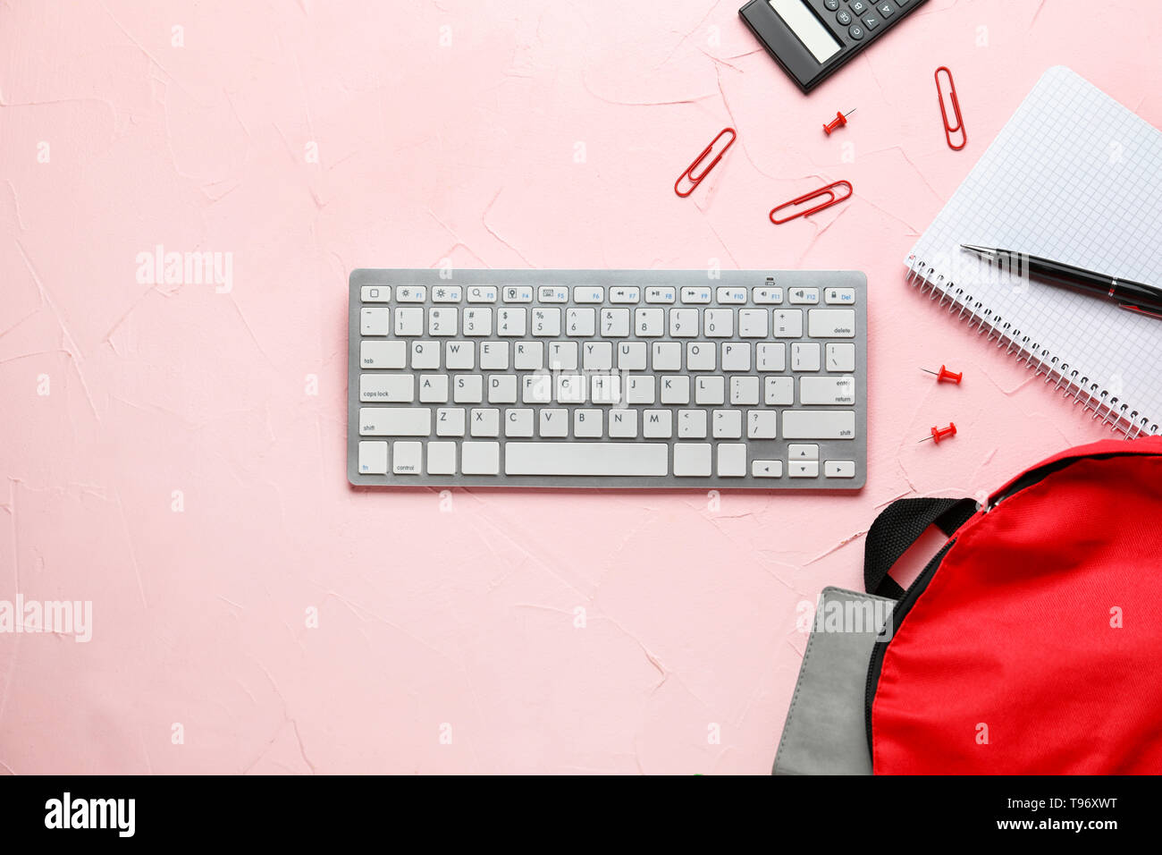 Composition with rucksack, keyboard and school stationery on color background Stock Photo
