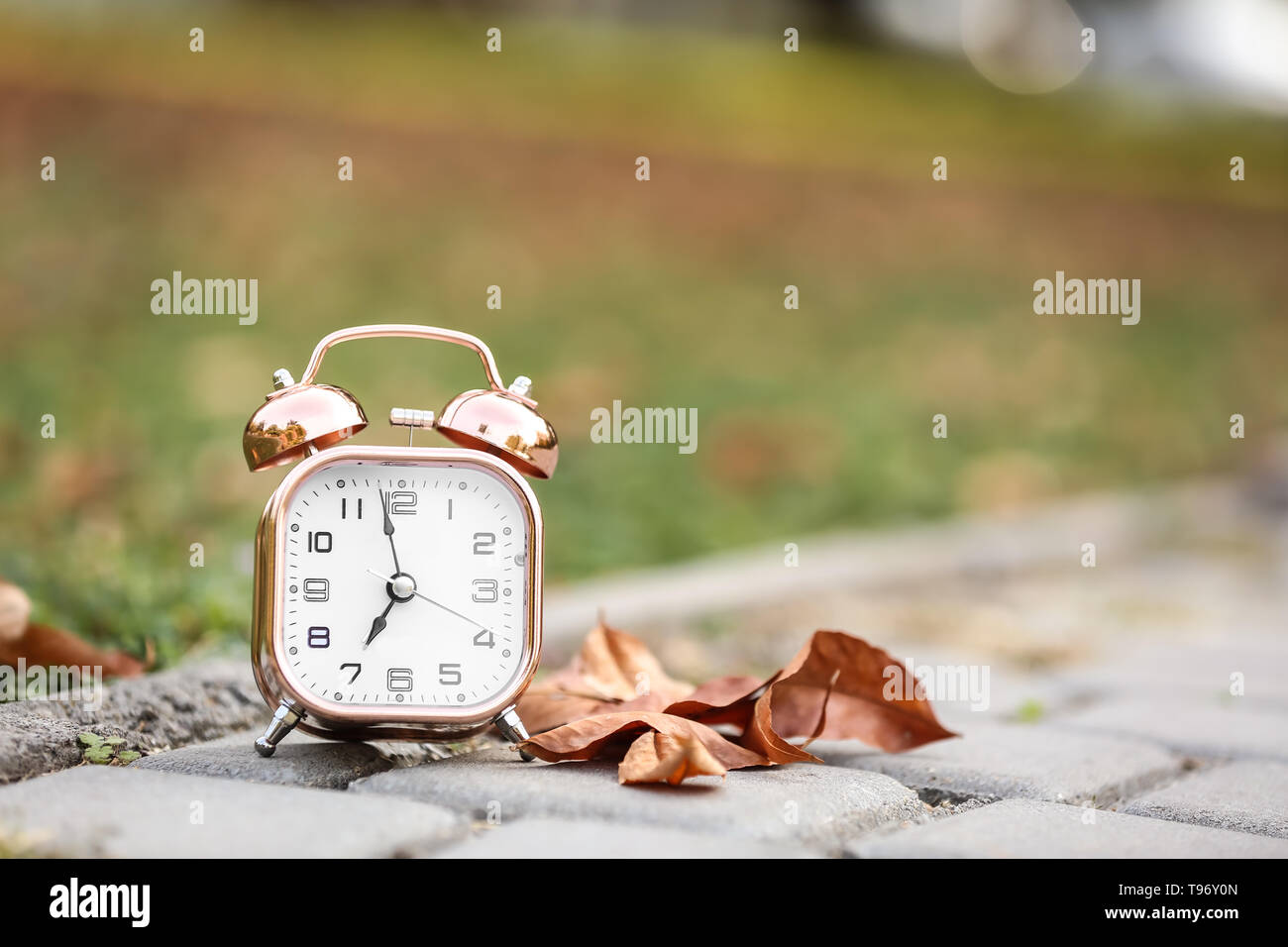 Alarm clock on ground outdoors Stock Photo