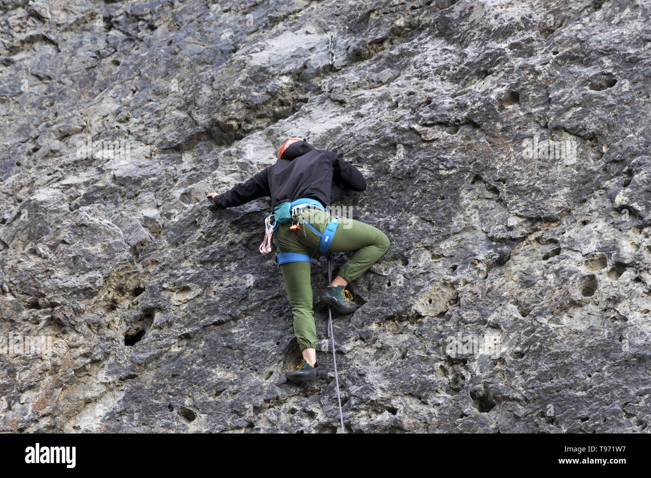 Athletic Male Climber Technical Climbing Vertical Rock Wall at Grassi Lakes above City of Canmore Canadian Rocky Mountains Stock Photo