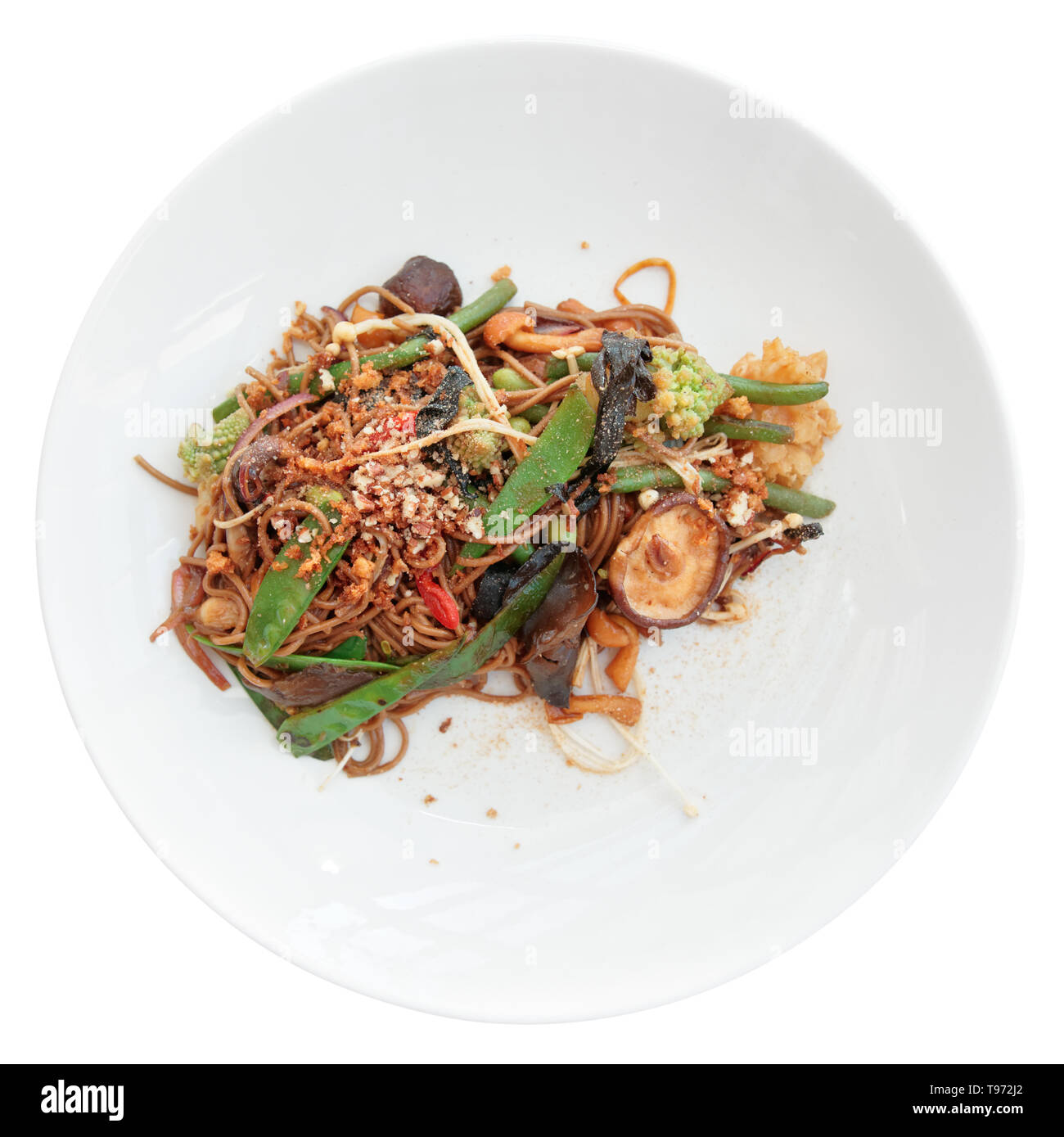 Buckwheat noodles with vegetables and mushrooms in round plate isolated