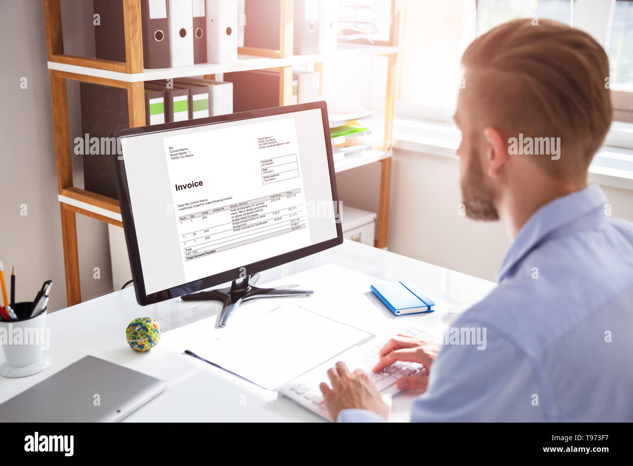 Businessperson Calculating E-Invoice Online On Computer At Office Stock Photo