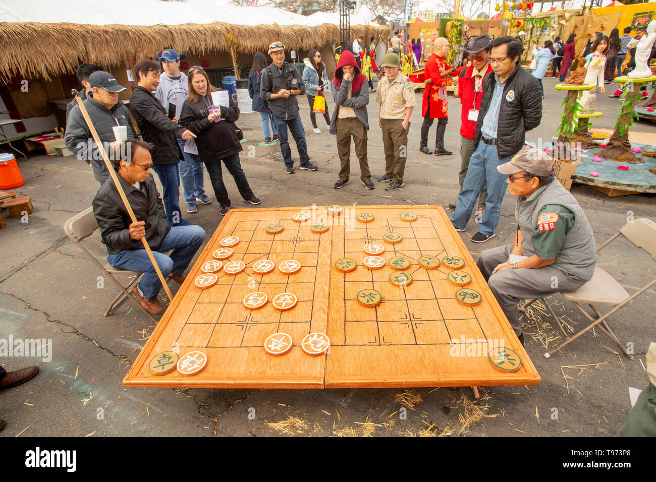 Vietnamese American men play a giant-size chess game at a Tet Lunar New Year festival in Costa Nesa, CA, as Boy Scouts watch. Stock Photo