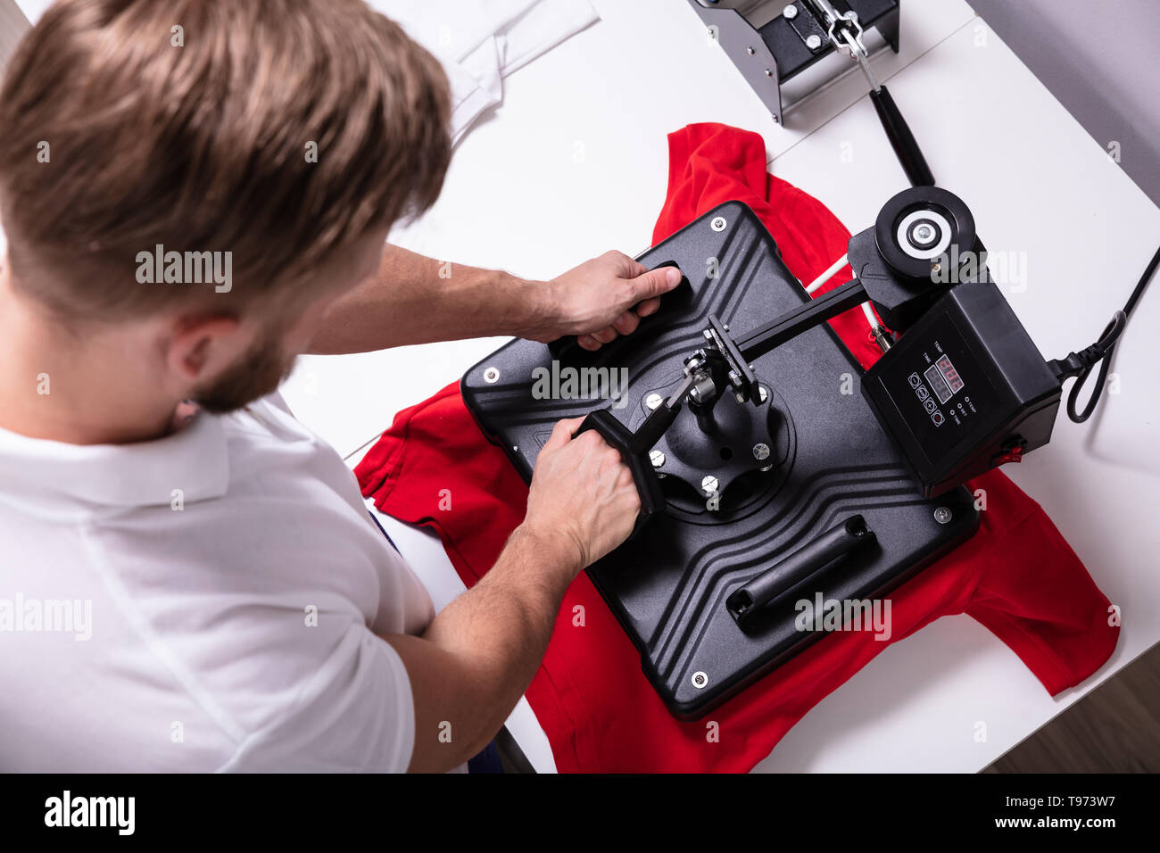 Man printing on t shirt in workshop Stock Photo