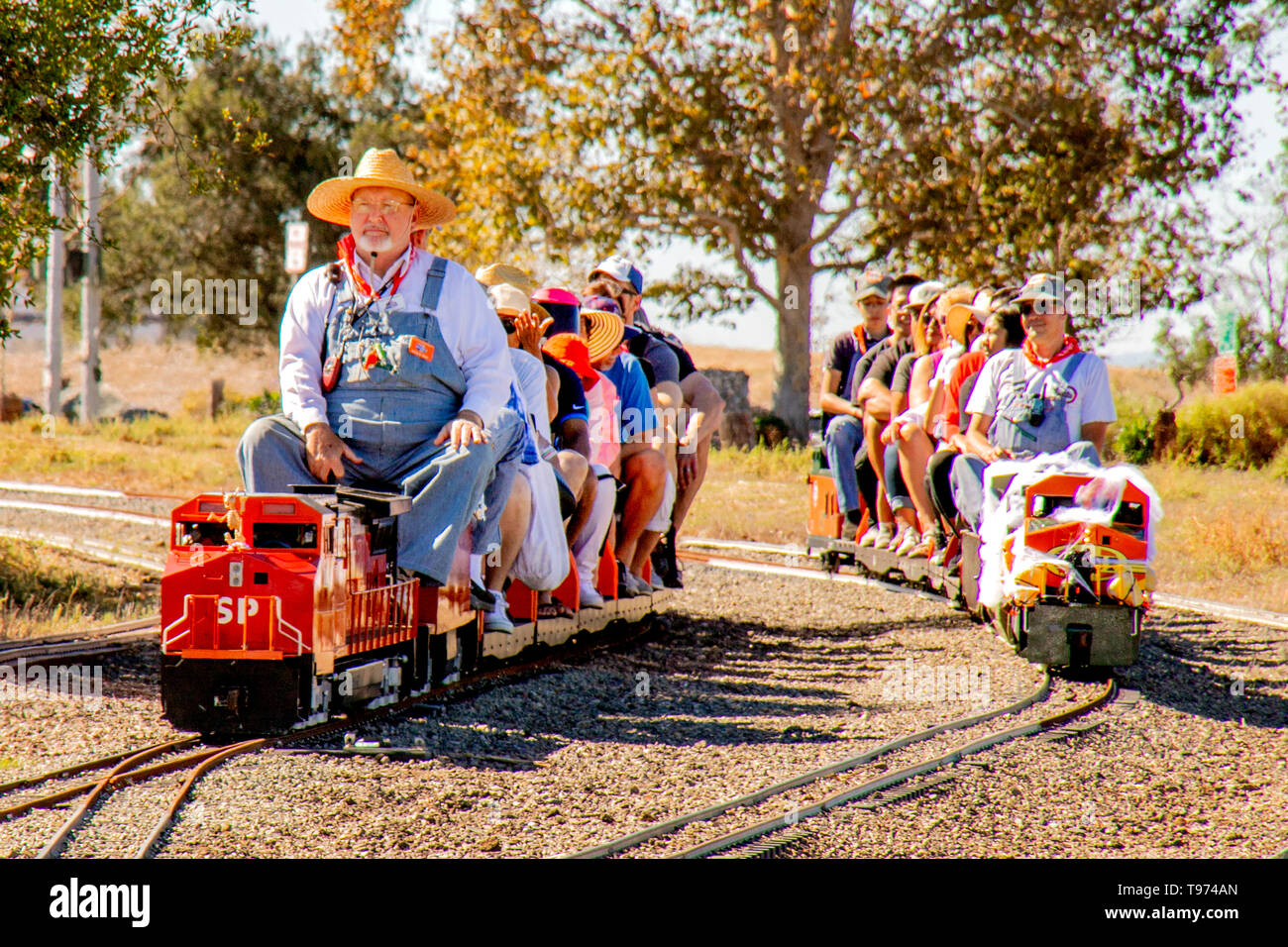 Sunny day passengers take a ride on two model trains in Costa Mesa, CA. Stock Photo