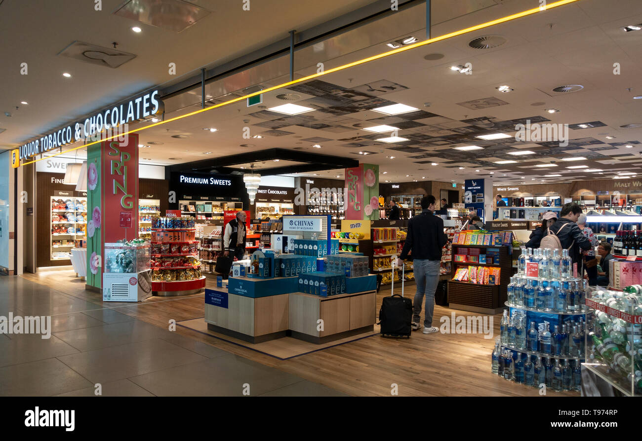 Customers in a duty-free shop selling Liquor, Tobacco and Chocolates at Schiphol Airport, Amsterdam, the Netherlands. Stock Photo