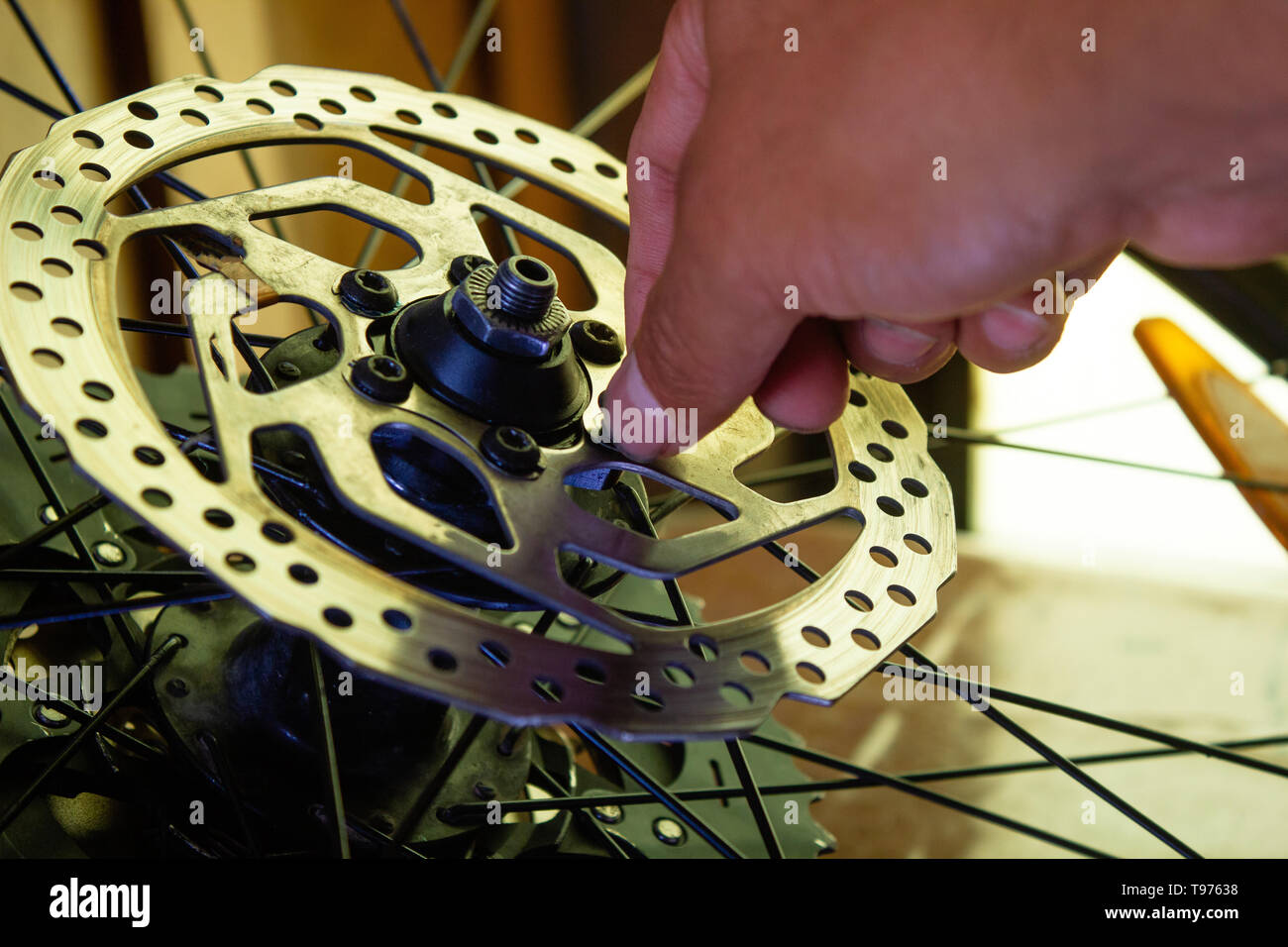 a mechanic removing the bolts from the rotor, mountain bike equipment and maintenance, service Stock Photo